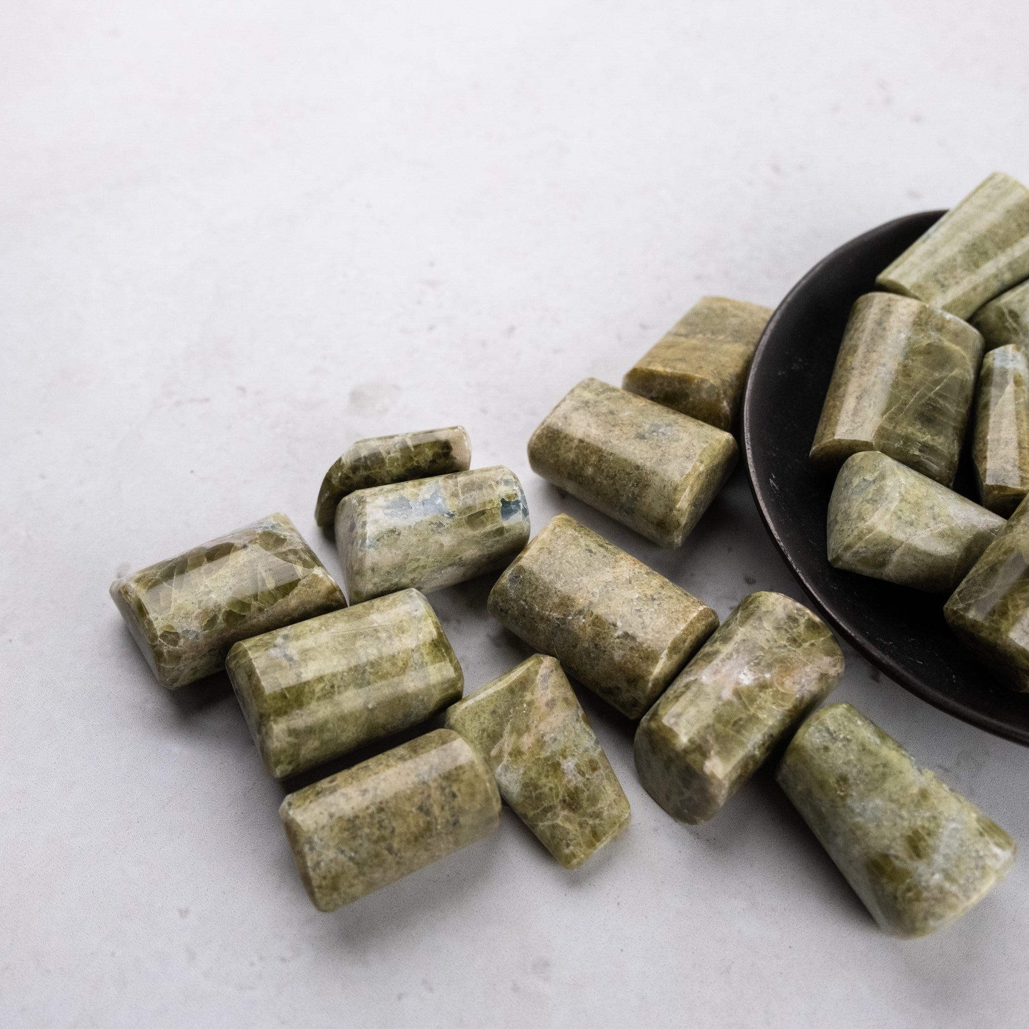 Vesonite tumble stone from Noctis Studio showing smooth, polished, rounded gemstone with vibrant green and black hues.