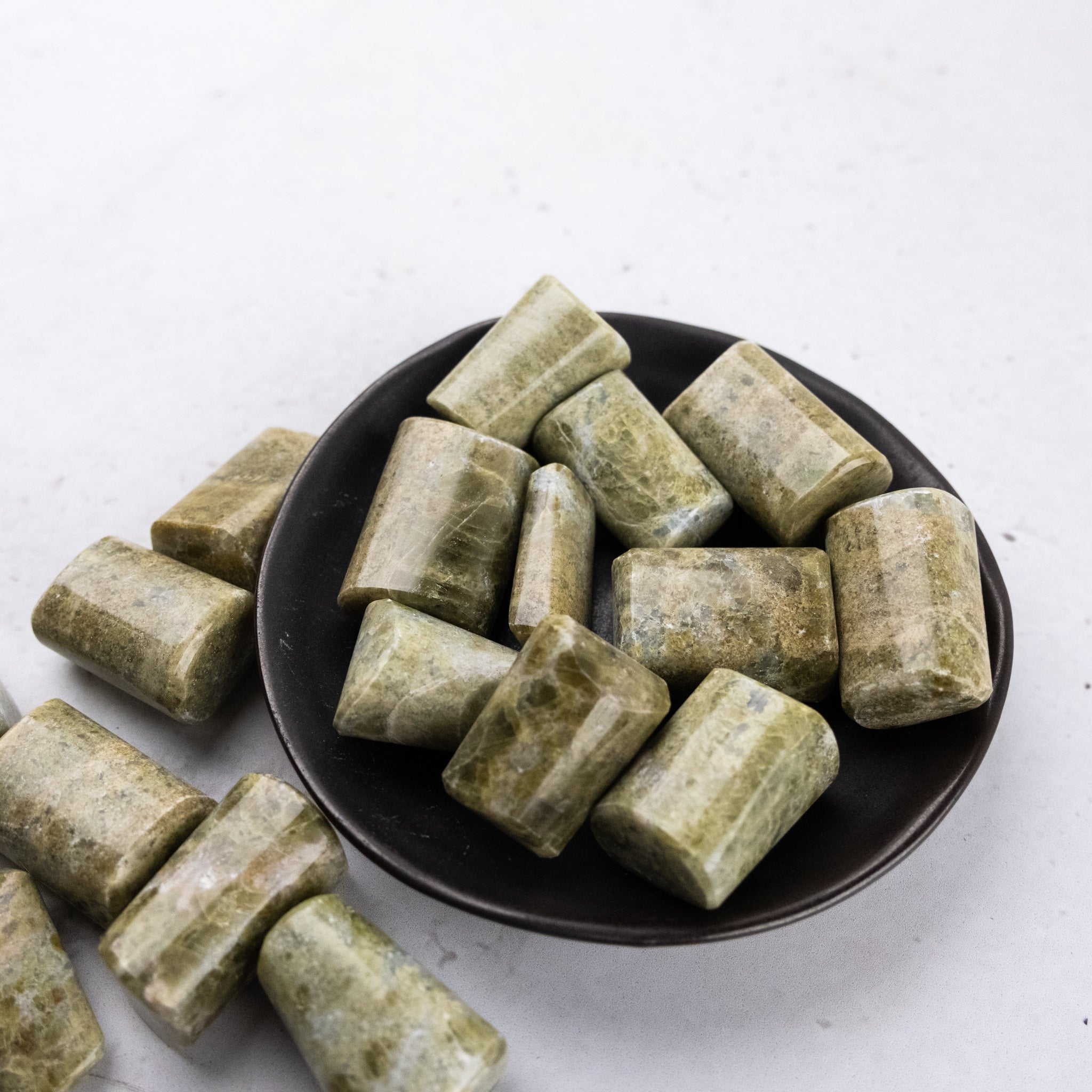 Vesonite tumble stone from Noctis Studio showing polished, rounded gemstone with vibrant green and black coloration.