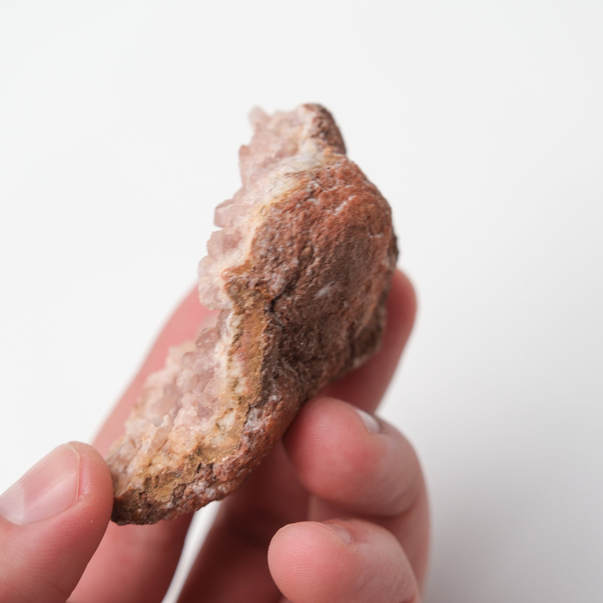 Pink Amethyst geode from Noctis Studio with vibrant purple crystals and a rugged stone exterior, showcasing natural mineral formations.