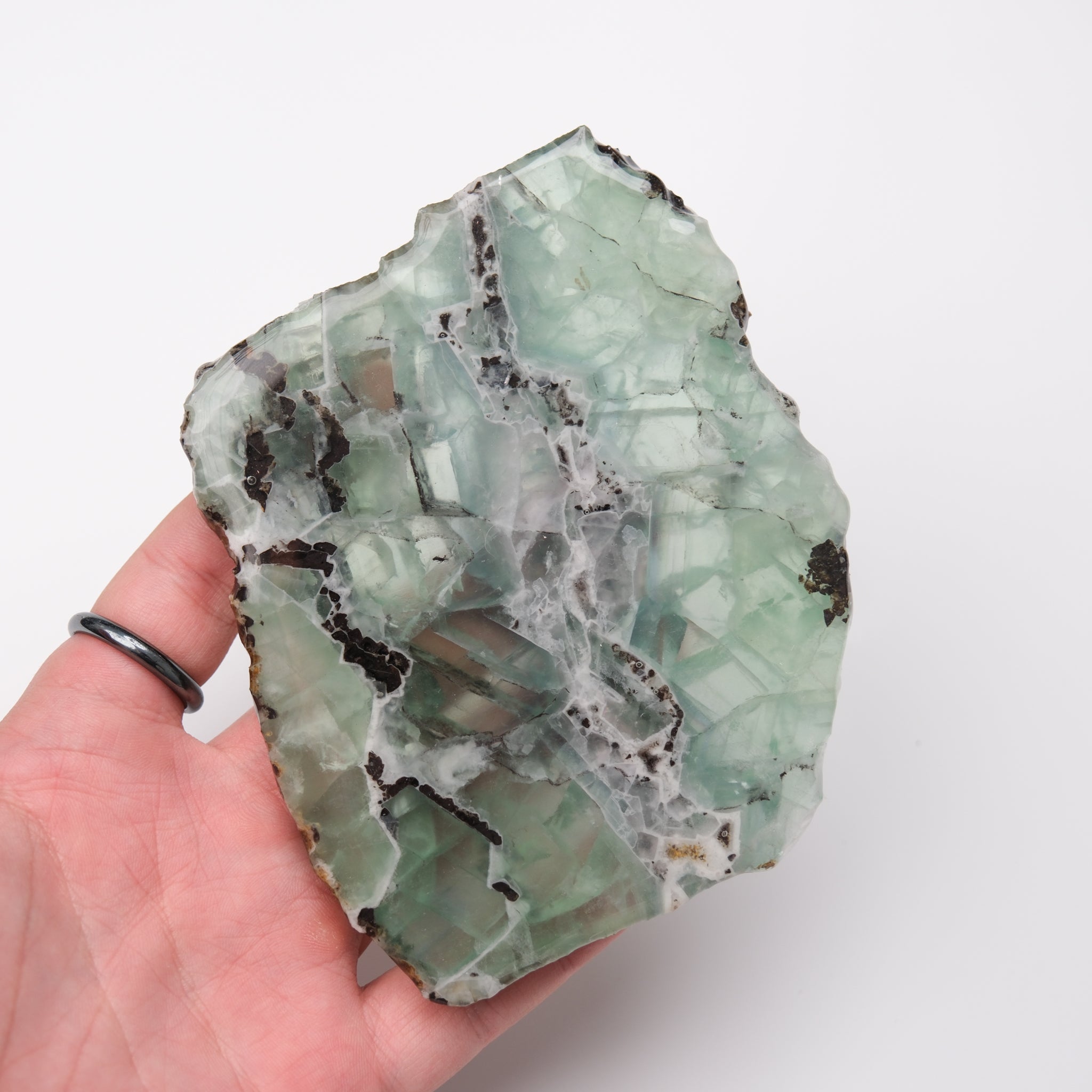 Noctis Studio fluorite slab showing vibrant green and purple mineral patterns on a smooth surface.