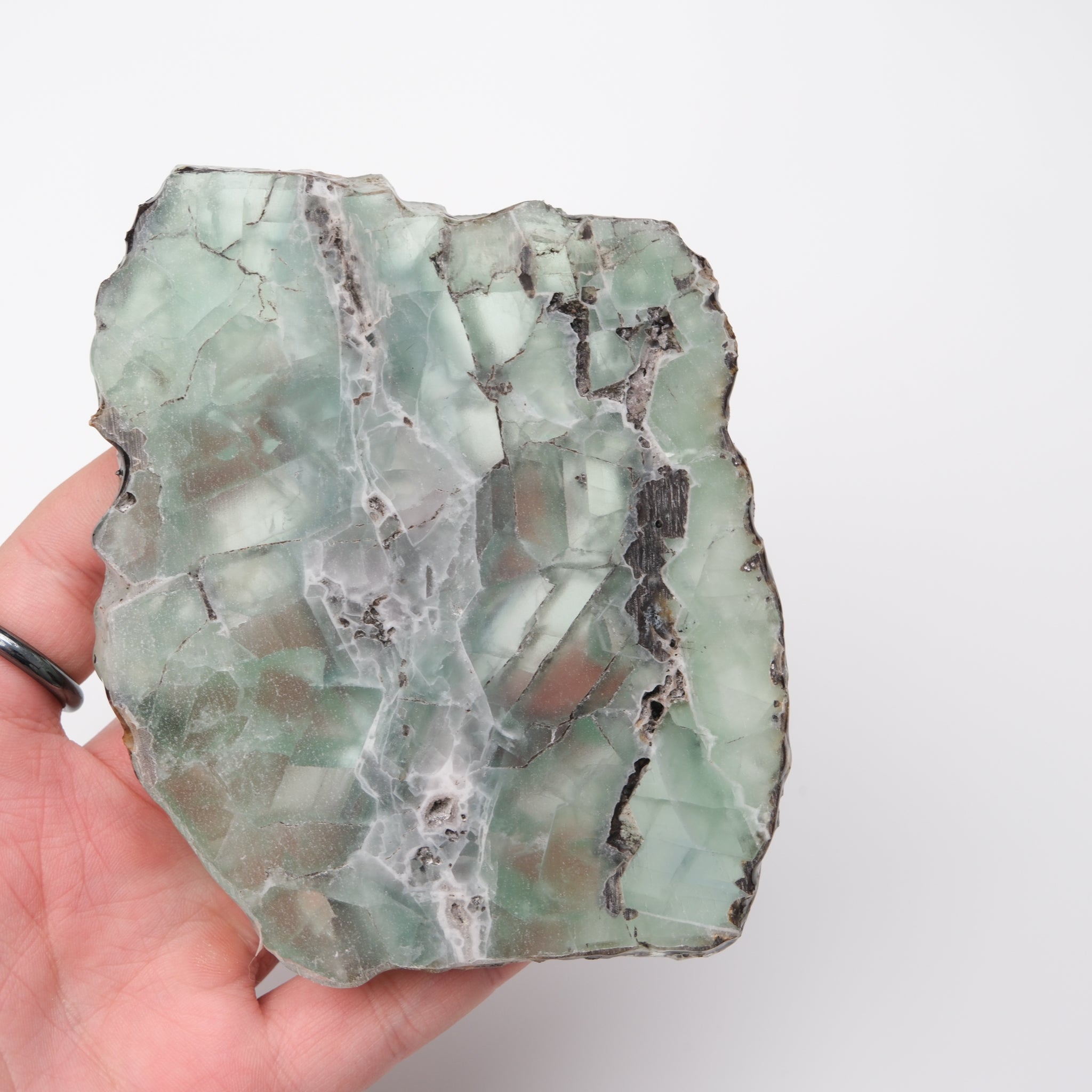 Large fluorite slab by Noctis Studio featuring vibrant green and purple hues, polished surface, and natural mineral patterns.