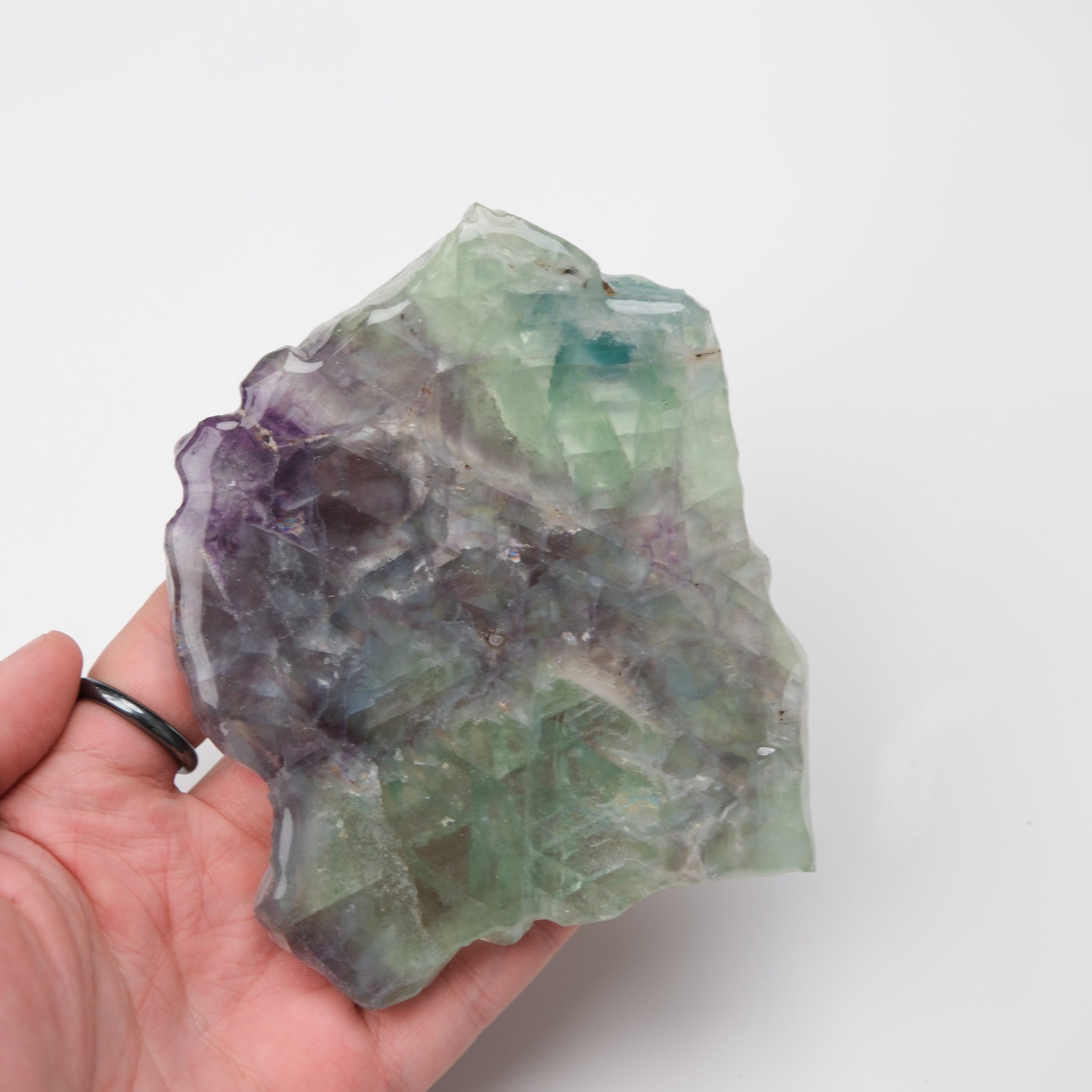 Noctis Studio fluorite slab with vibrant green, purple, and blue mineral colors, smooth polished surface, and natural stone patterns.