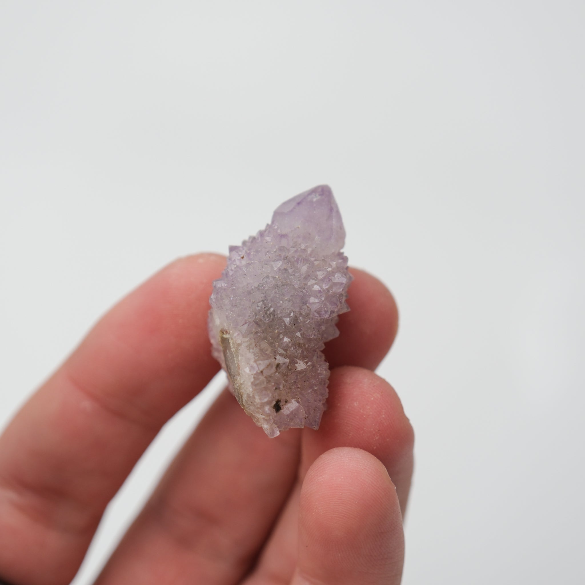Noctis Studio Spirit Quartz cluster with clear, crystalline formations and vibrant purple hues on a neutral background.