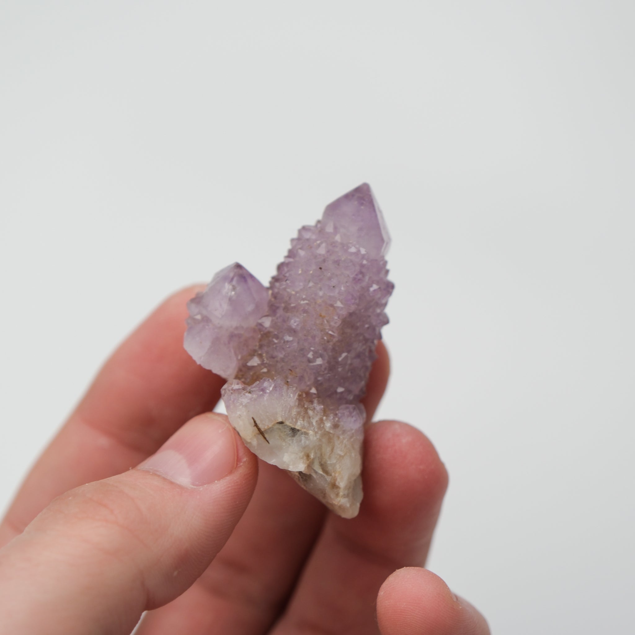 Noctis Studio Spirit Quartz cluster with multiple translucent, lavender and clear crystal points on a white background.