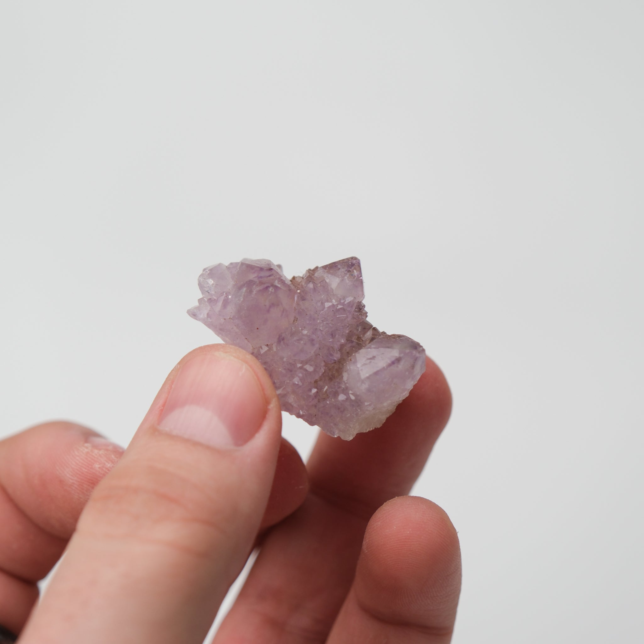 Pink spirit quartz cluster with multiple crystal points and vibrant color, displayed on a neutral background.