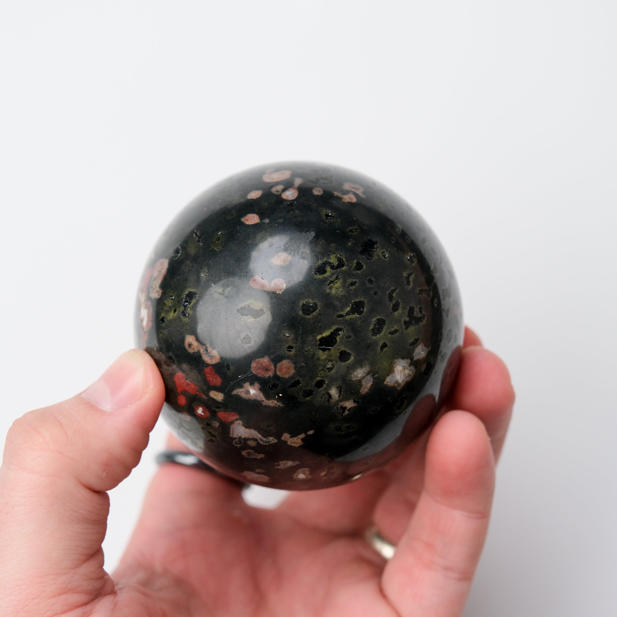 Cinnabar Peridotite sphere from Noctis Studio, showing a polished, round mineral with rich red and green hues.