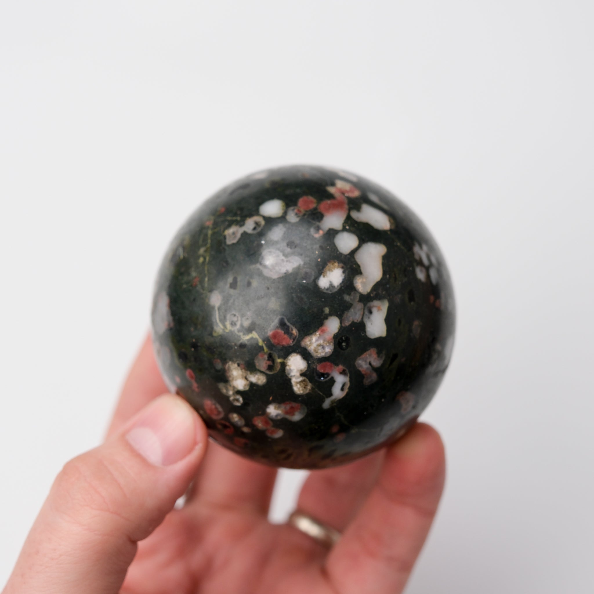 Cinnabar Peridotite Sphere by Noctis Studio, smooth polished mineral sphere with rich red and green mineral patterns.
