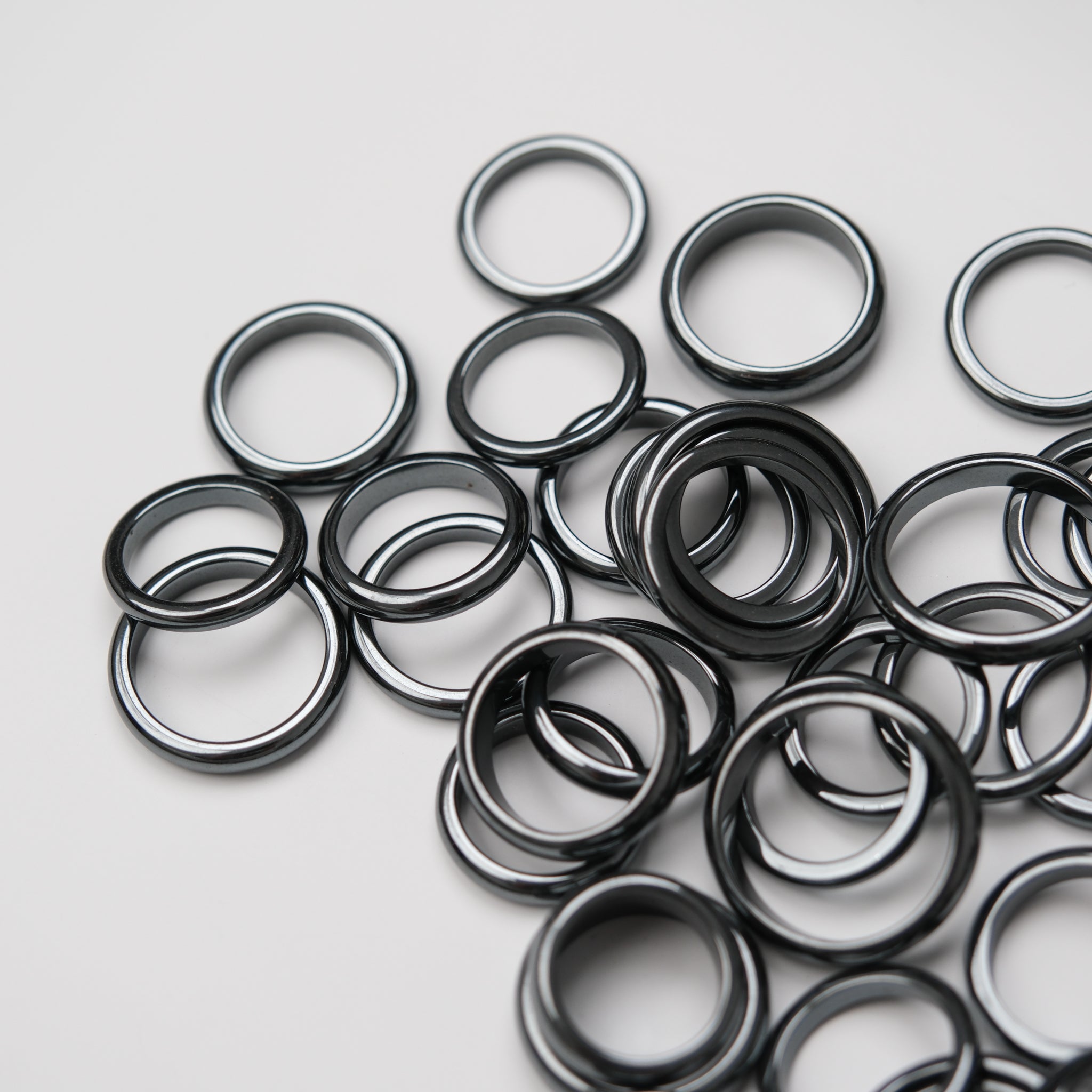Two hematite rings displayed on a crystal stand, showcasing Noctis Studio's stylish jewelry and elegant presentation.