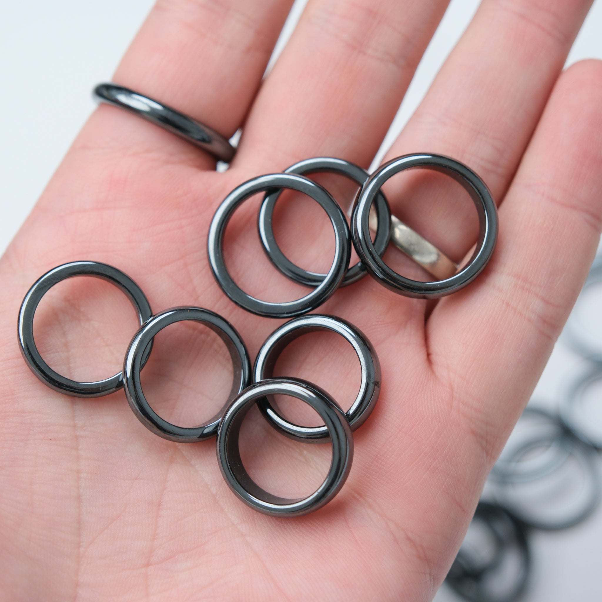 Pair of Noctis Studio hematite rings with crystal stands, showcasing sleek black rings on elegant display stands.