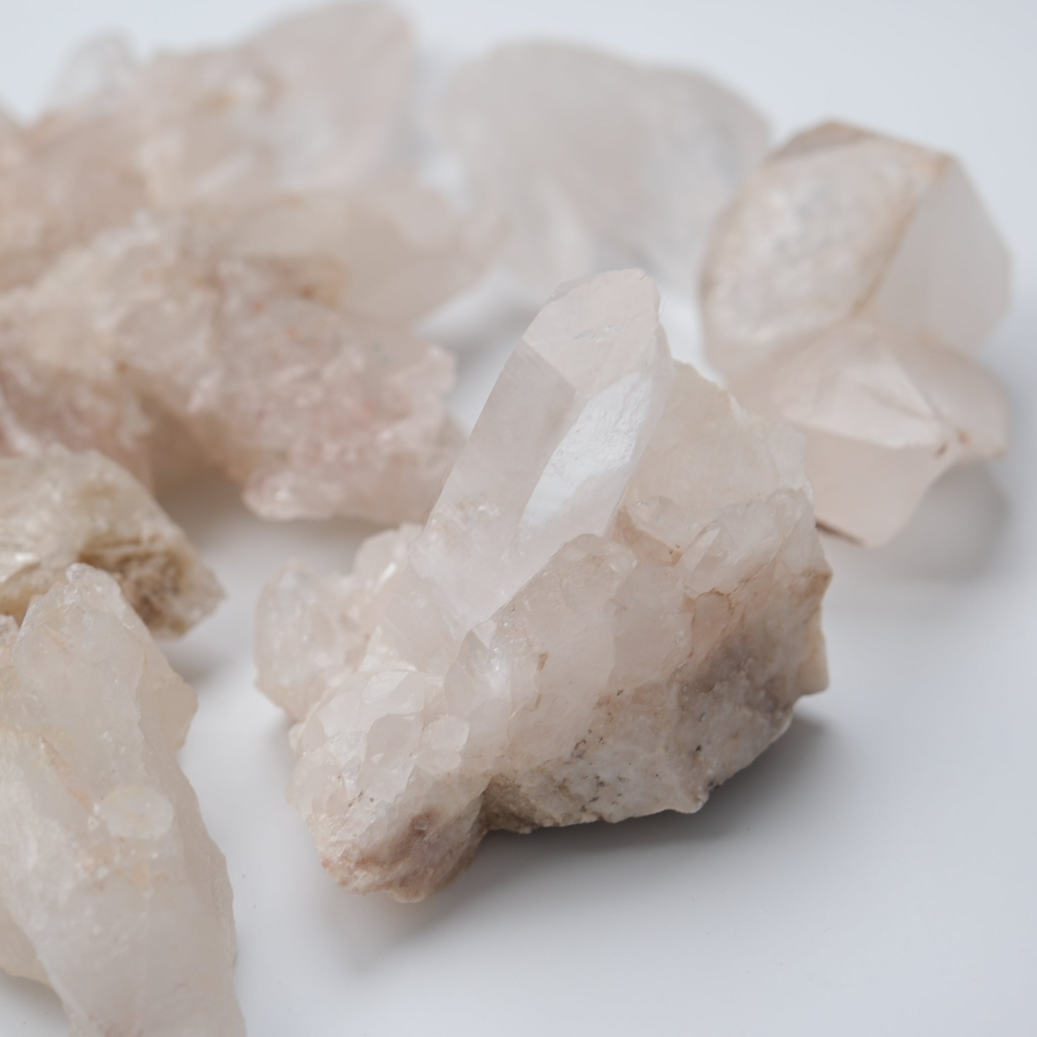 Himalayan quartz crystal cluster from Noctis Studio with clear, pink-toned quartz points arranged naturally on a base.