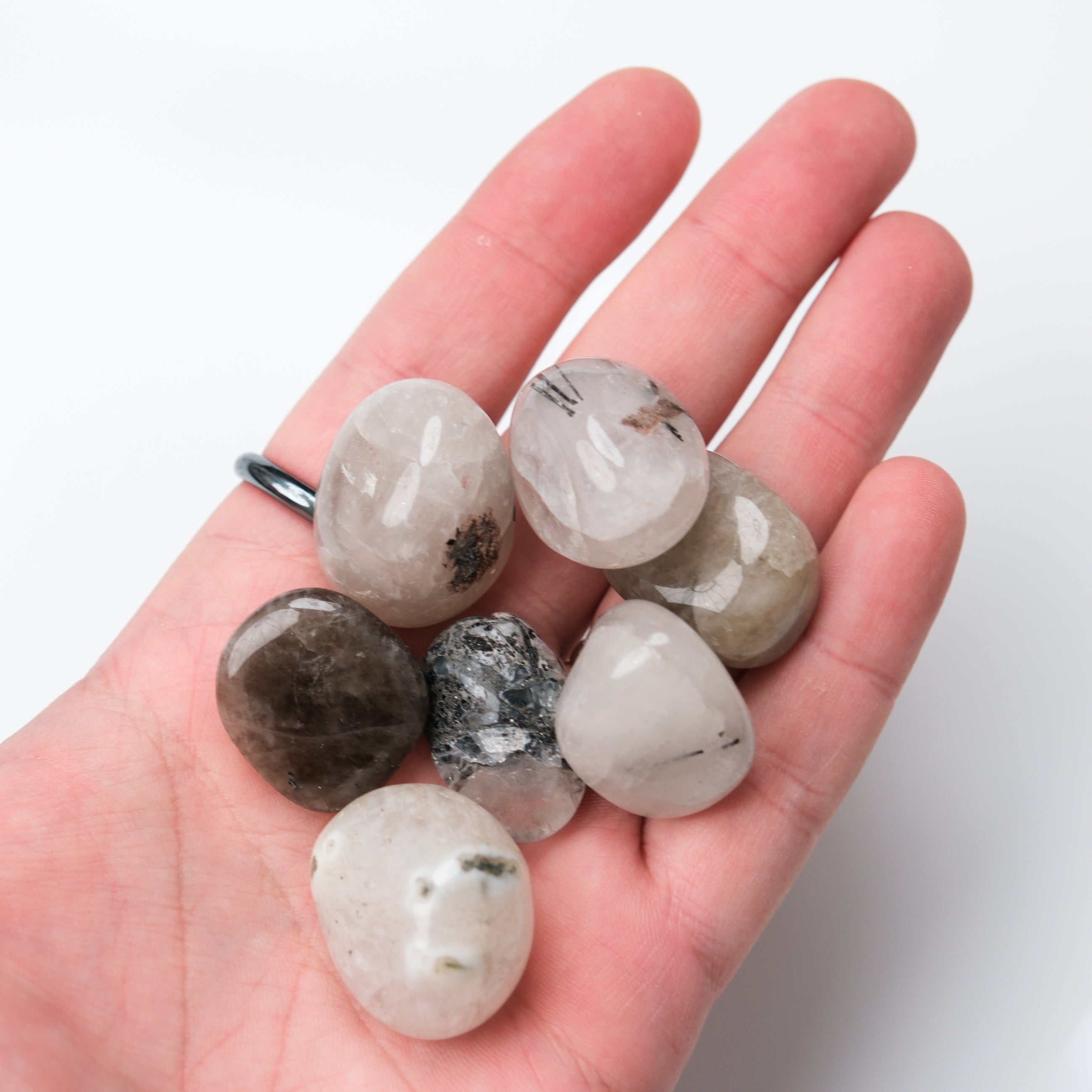 Tourmalinated Quartz tumble stone from Noctis Studio showing black tourmaline inclusions within clear quartz crystal.
