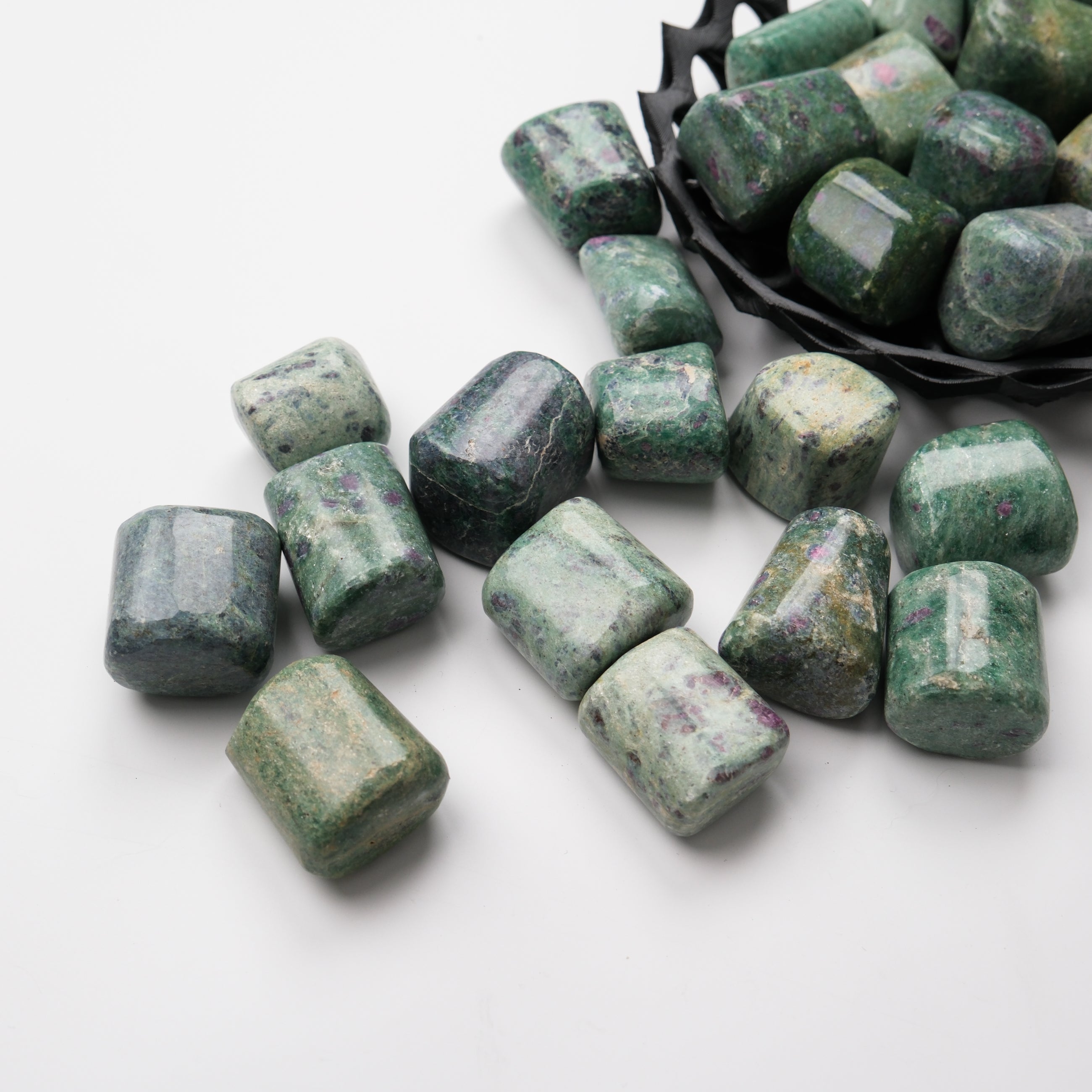 Ruby in Fuschite tumble stone from Noctis Studio, showcasing a polished gemstone with vibrant red ruby and green fuschite mineral patterns.