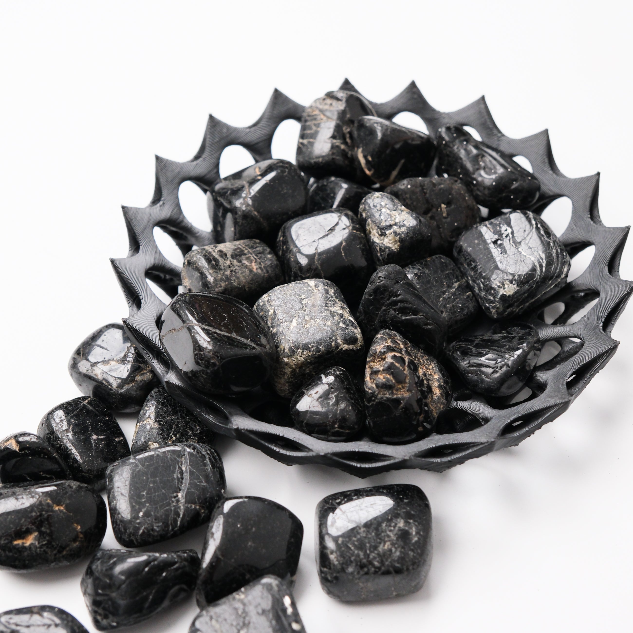 Black Tourmaline tumble stone from Noctis Studio, showcasing a polished black mineral with natural texture and irregular shape.