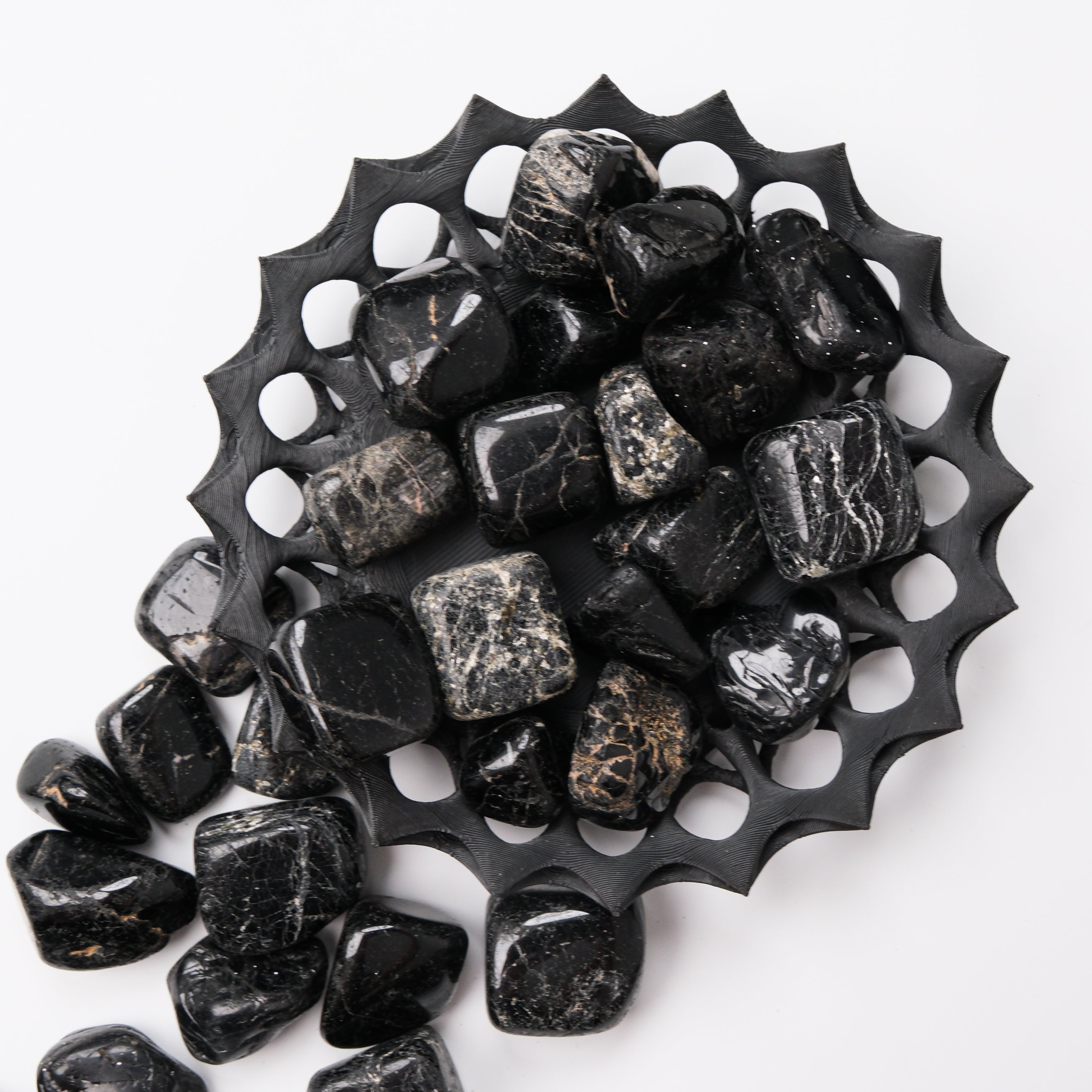 Black Tourmaline tumble stone from Noctis Studio showing a polished, irregular black mineral with natural texture and shine.
