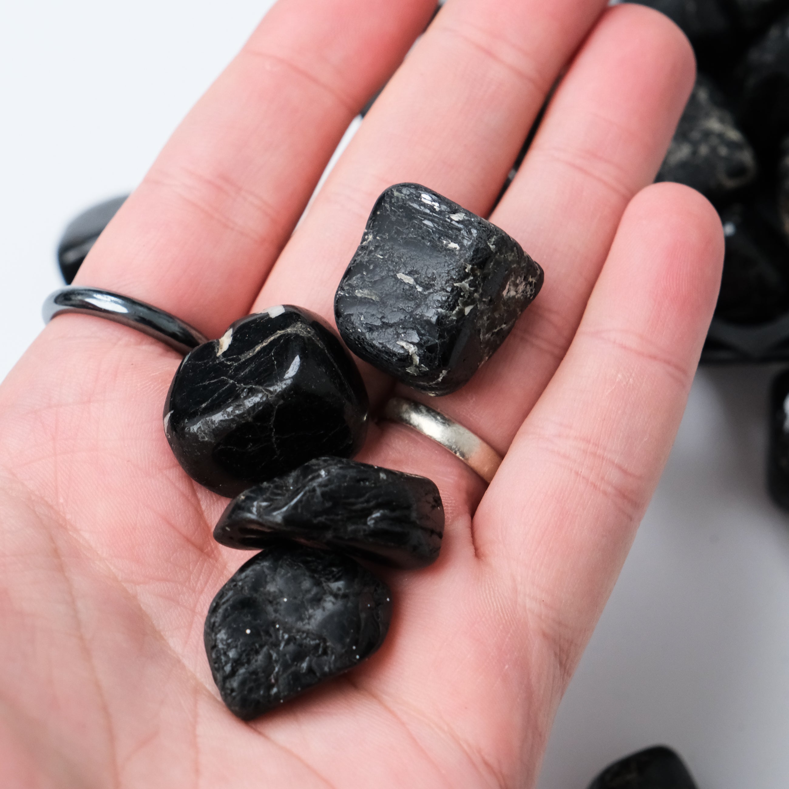 Black Tourmaline tumble stone from Noctis Studio, polished mineral specimen with smooth, rounded surface and deep black color.