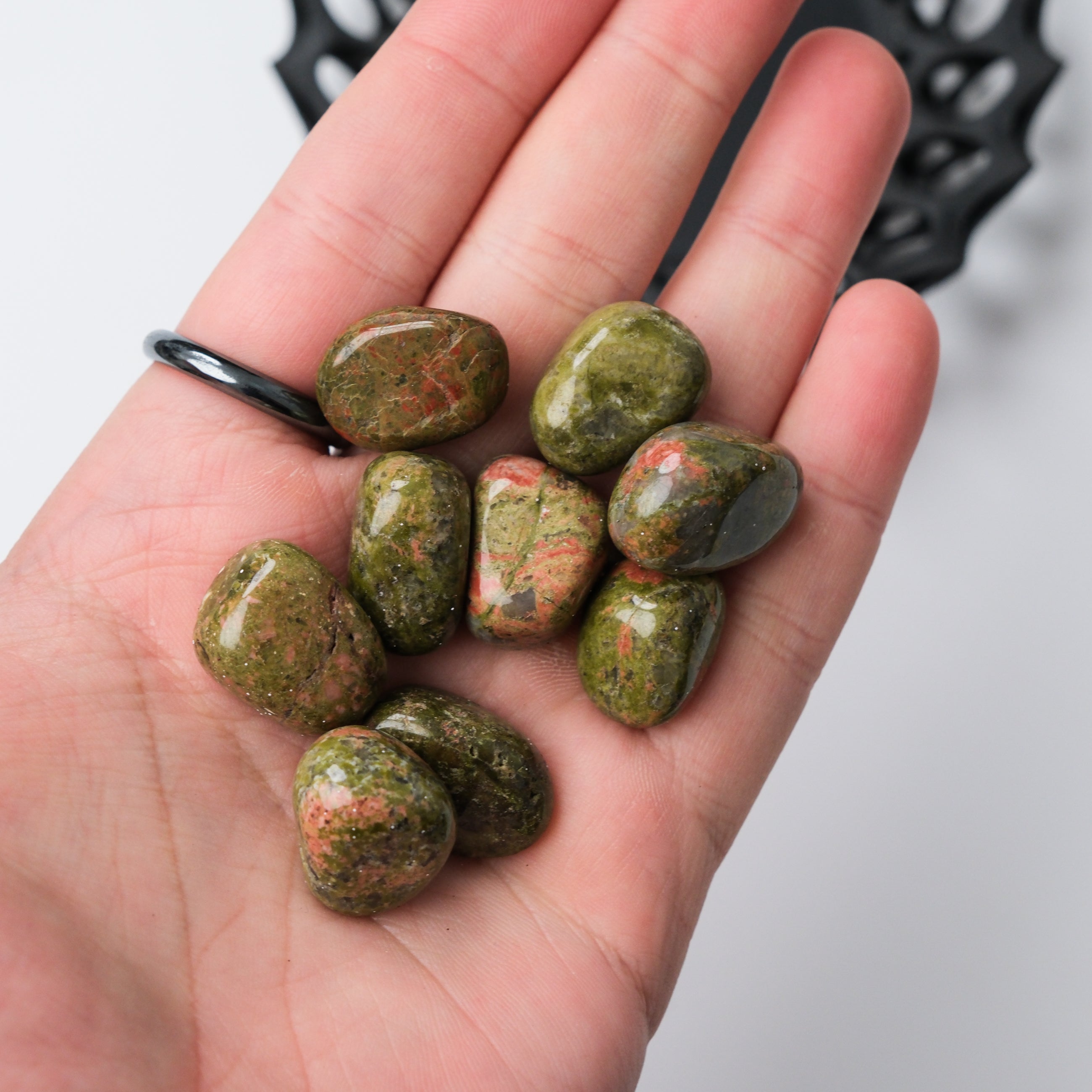 Unakite tumble stone from Noctis Studio showing a smooth, polished pink and green mineral specimen with natural patterns