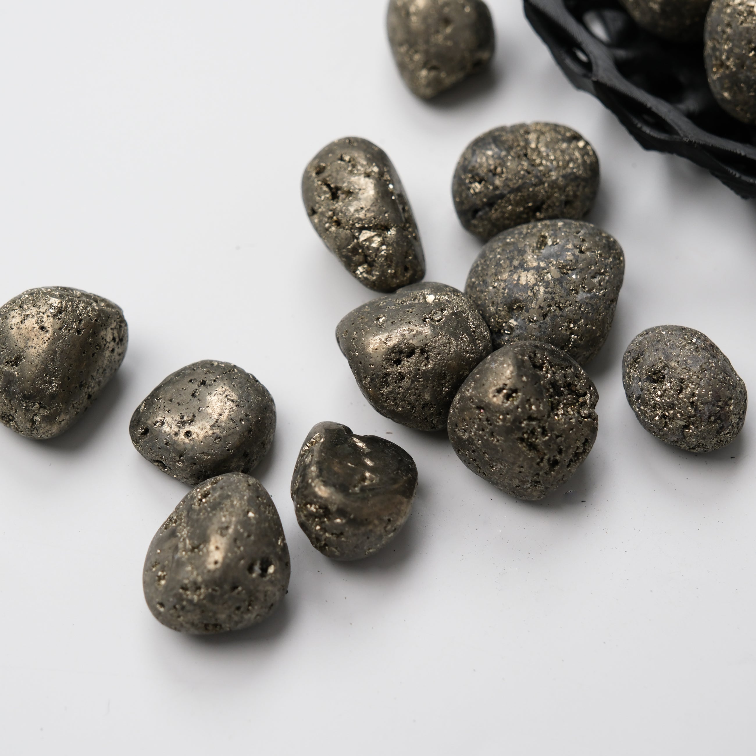 Noctis Studio pyrite tumble stone showing metallic gold surface and irregular shape on a neutral background.