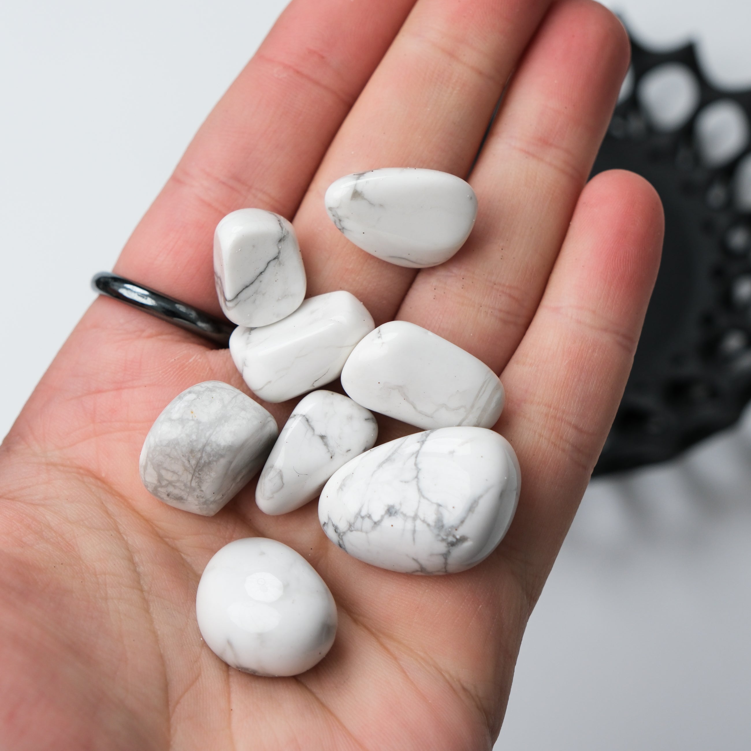 White Howlite tumble stone from Noctis Studio, showing smooth, polished white stone with gray veining on a neutral background.