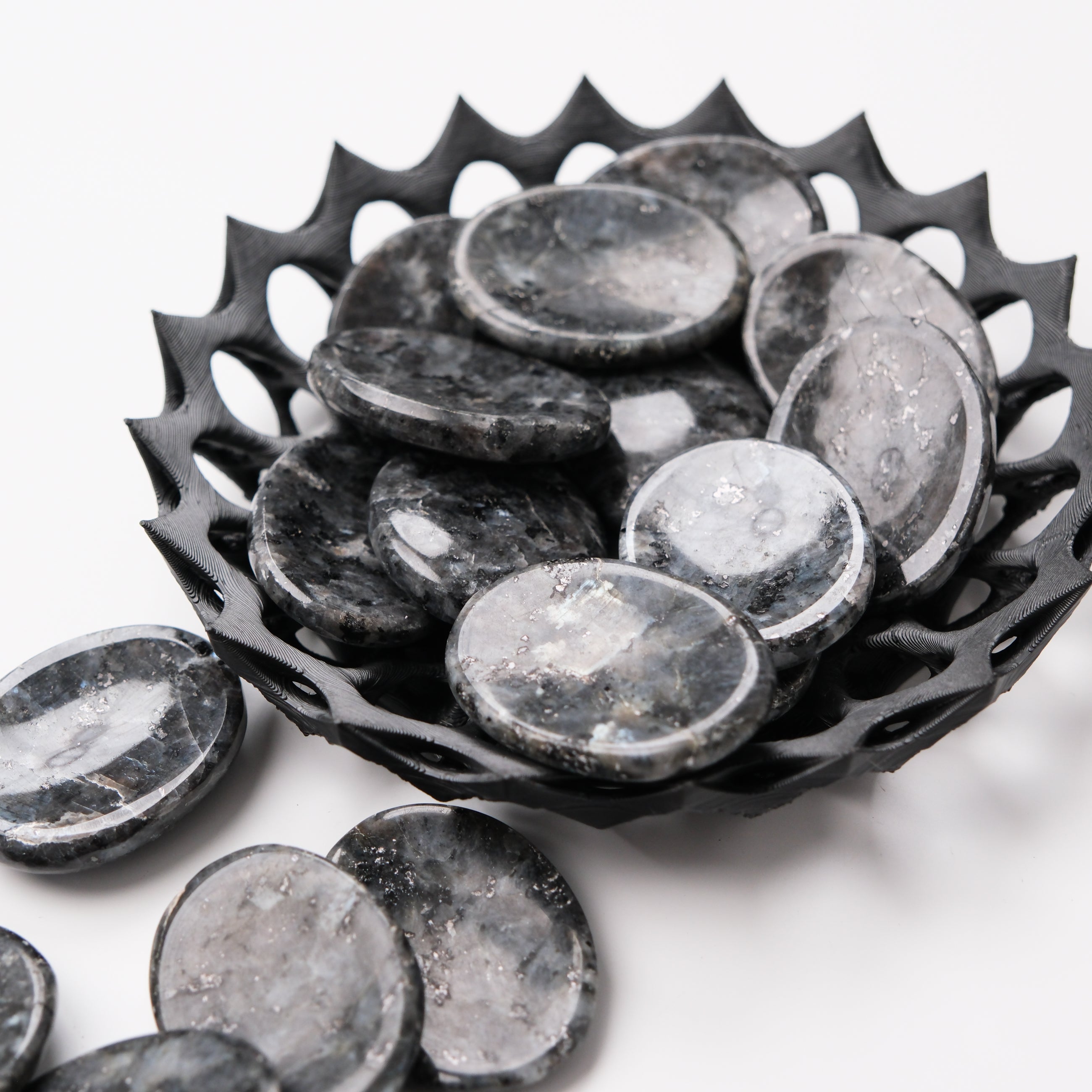 Larvikite worry stone from Noctis Studio showing polished, smooth dark gray and blue stone with natural patterns for comforting handling.