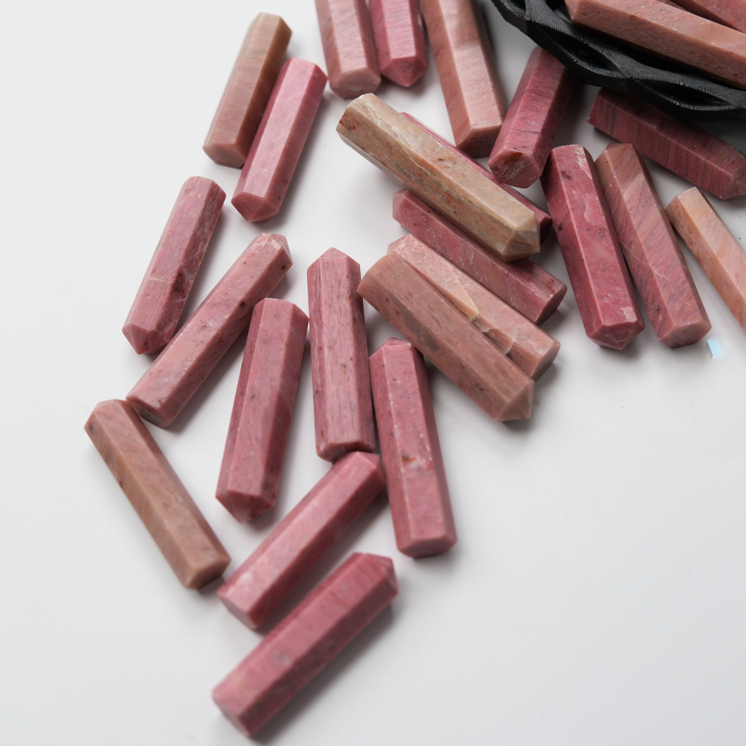 Pink petrified wood single gridding point from Noctis Studio, showcasing a polished natural stone tool with a pointed tip.