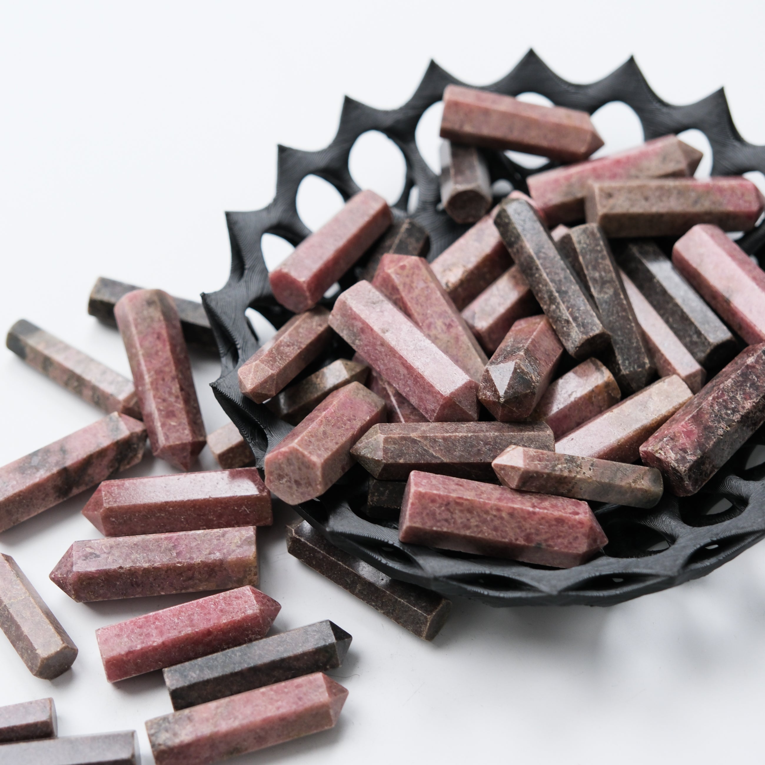 Rhodonite single gridding point tool by Noctis Studio, showing a polished pink and black stone with pointed tip for crystal grid work.