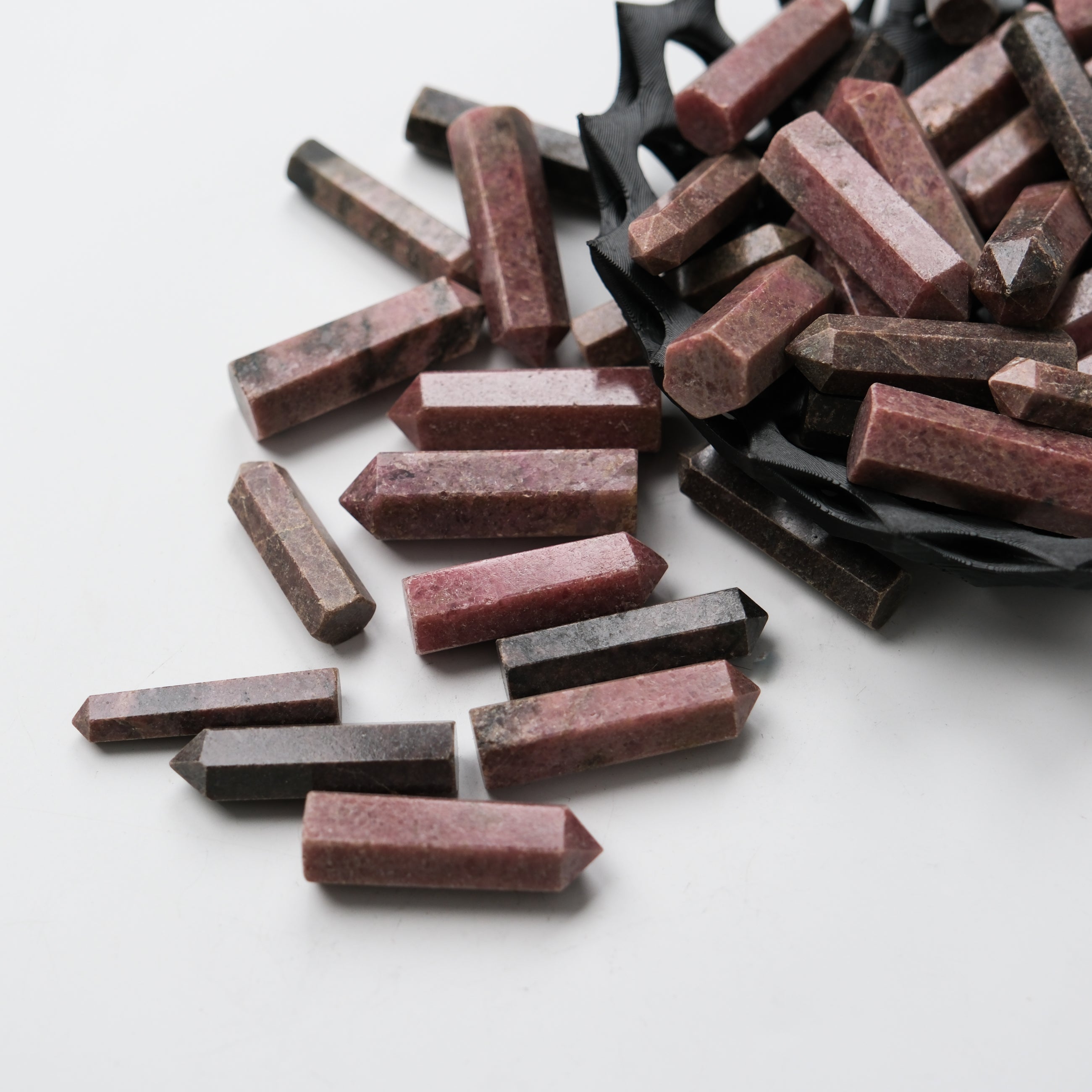 Rhodonite single gridding point from Noctis Studio, showing a polished pink and black stone tool for gemstone setting.