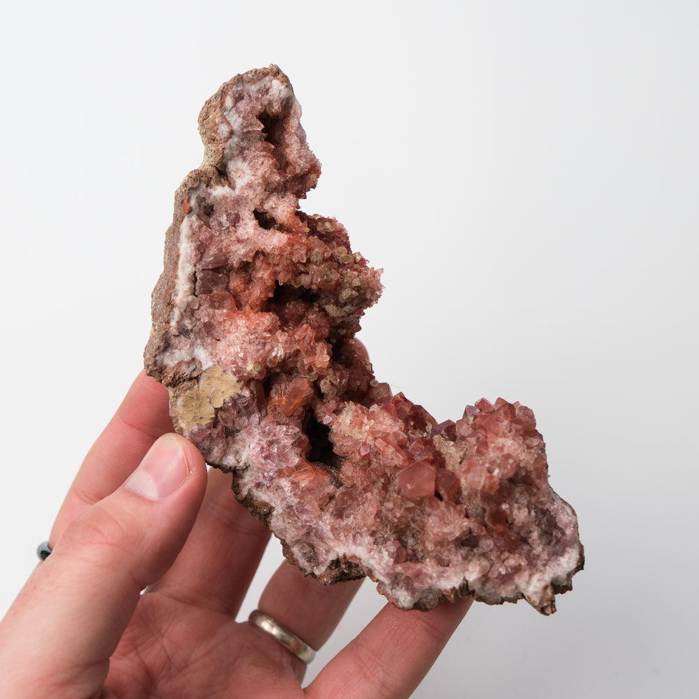 Pink Amethyst geode by Noctis Studio showing vibrant pink crystals and a rugged natural quartz exterior.