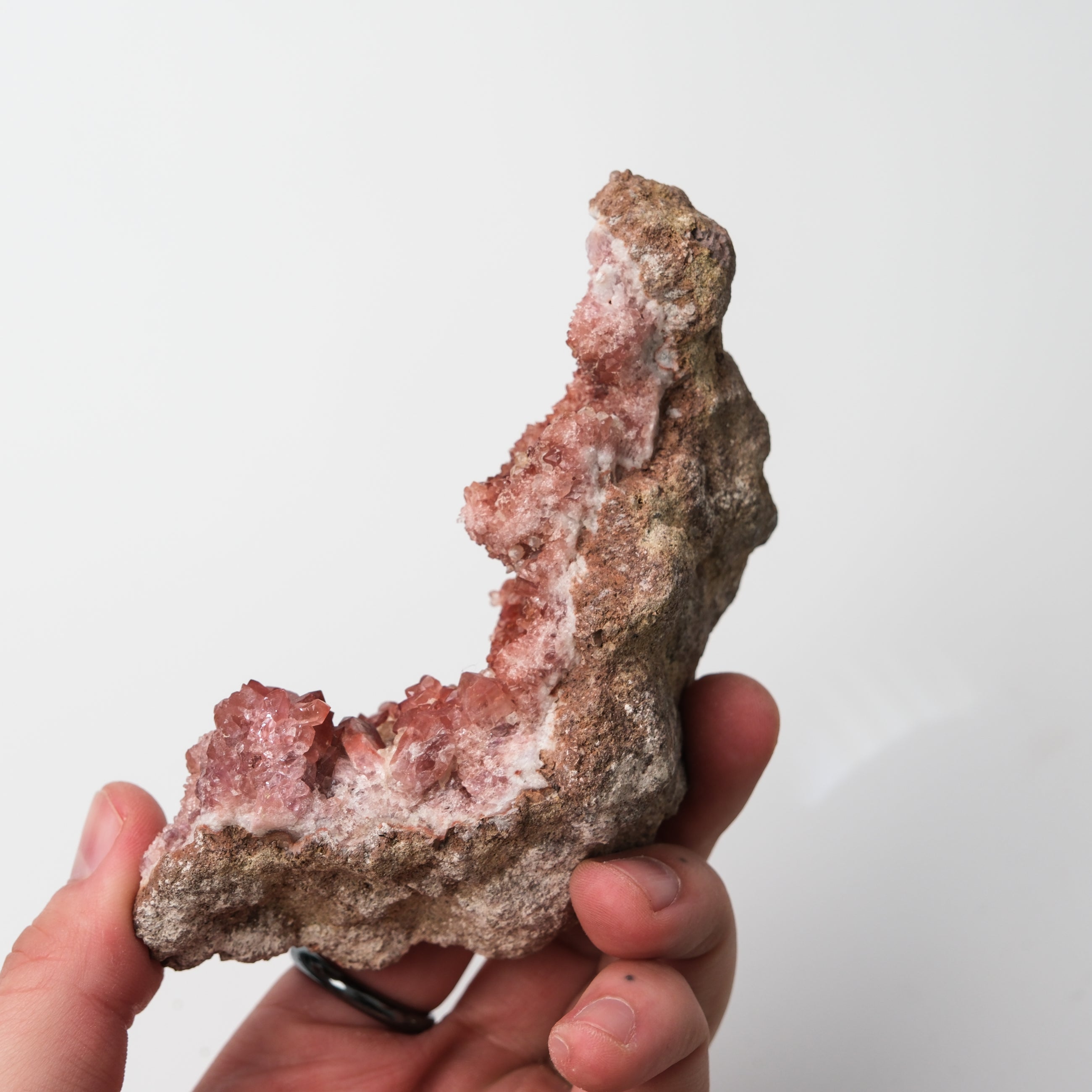 Pink Amethyst geode from Noctis Studio, showcasing vibrant pink crystals inside a rugged natural stone cavity.
