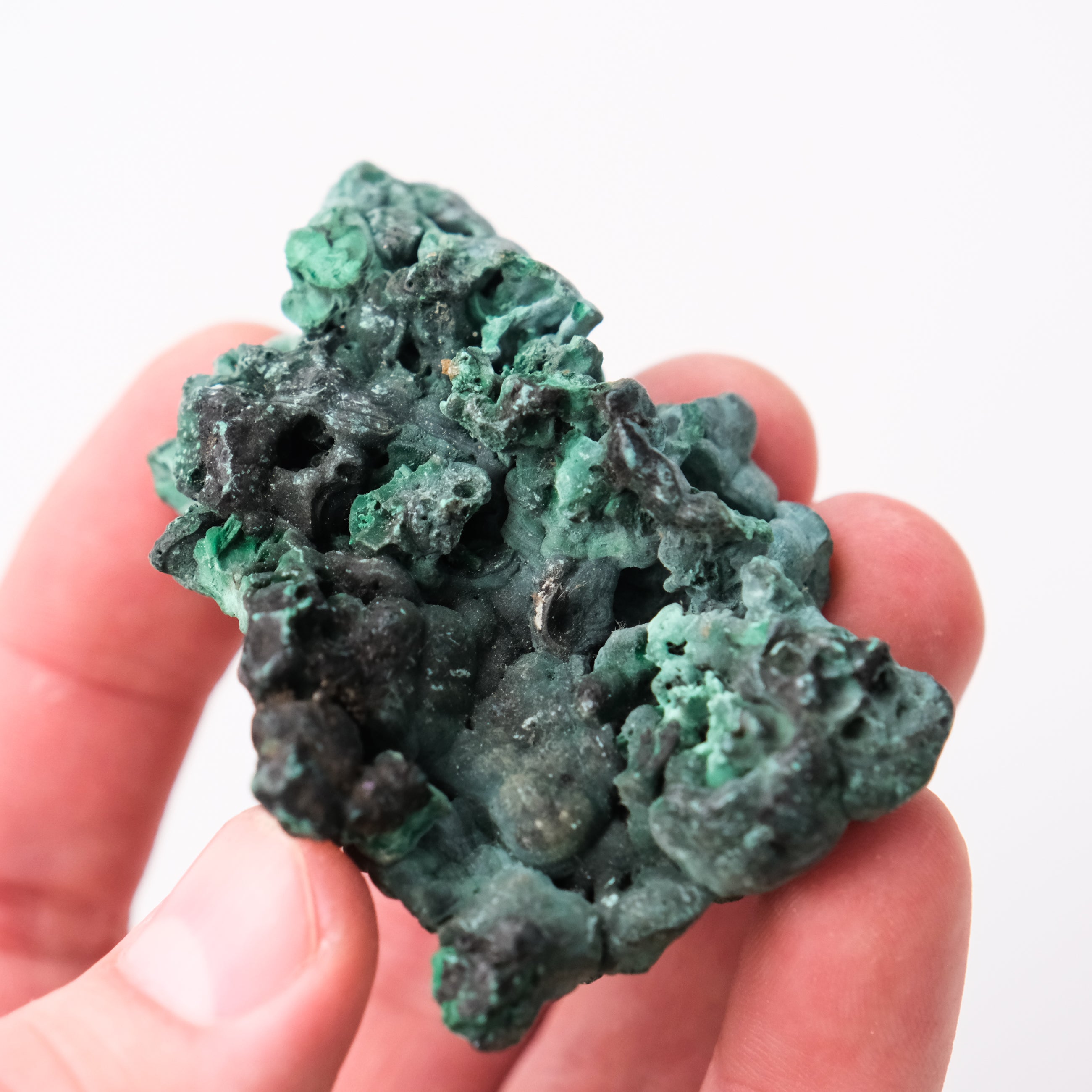 Malachite specimen from Noctis Studio showing vibrant green banded mineral patterns on a polished surface.