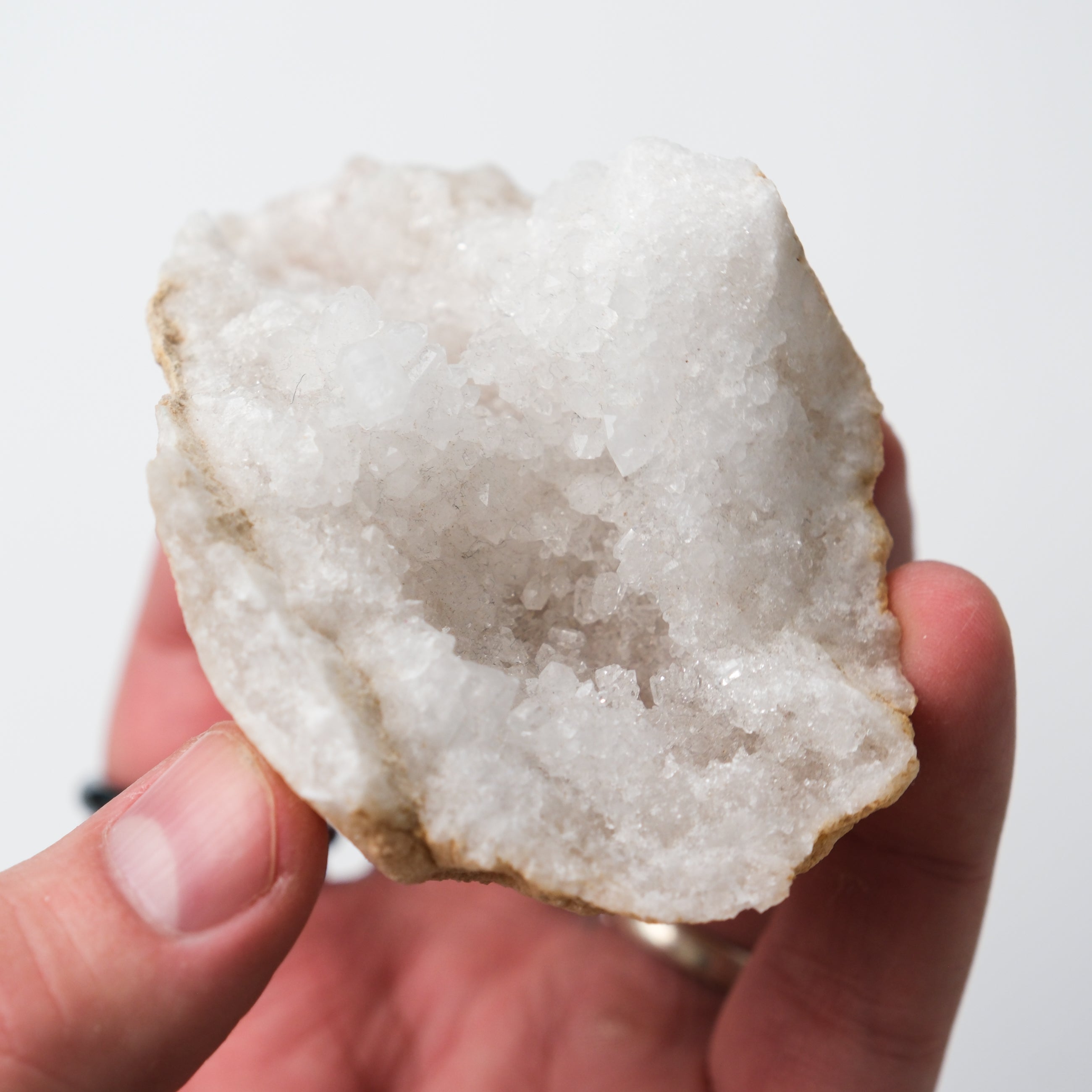 Moroccan Quartz Geode from Noctis Studio featuring sparkling crystals and a hollow, volcanic rock cavity with natural mineral formations.