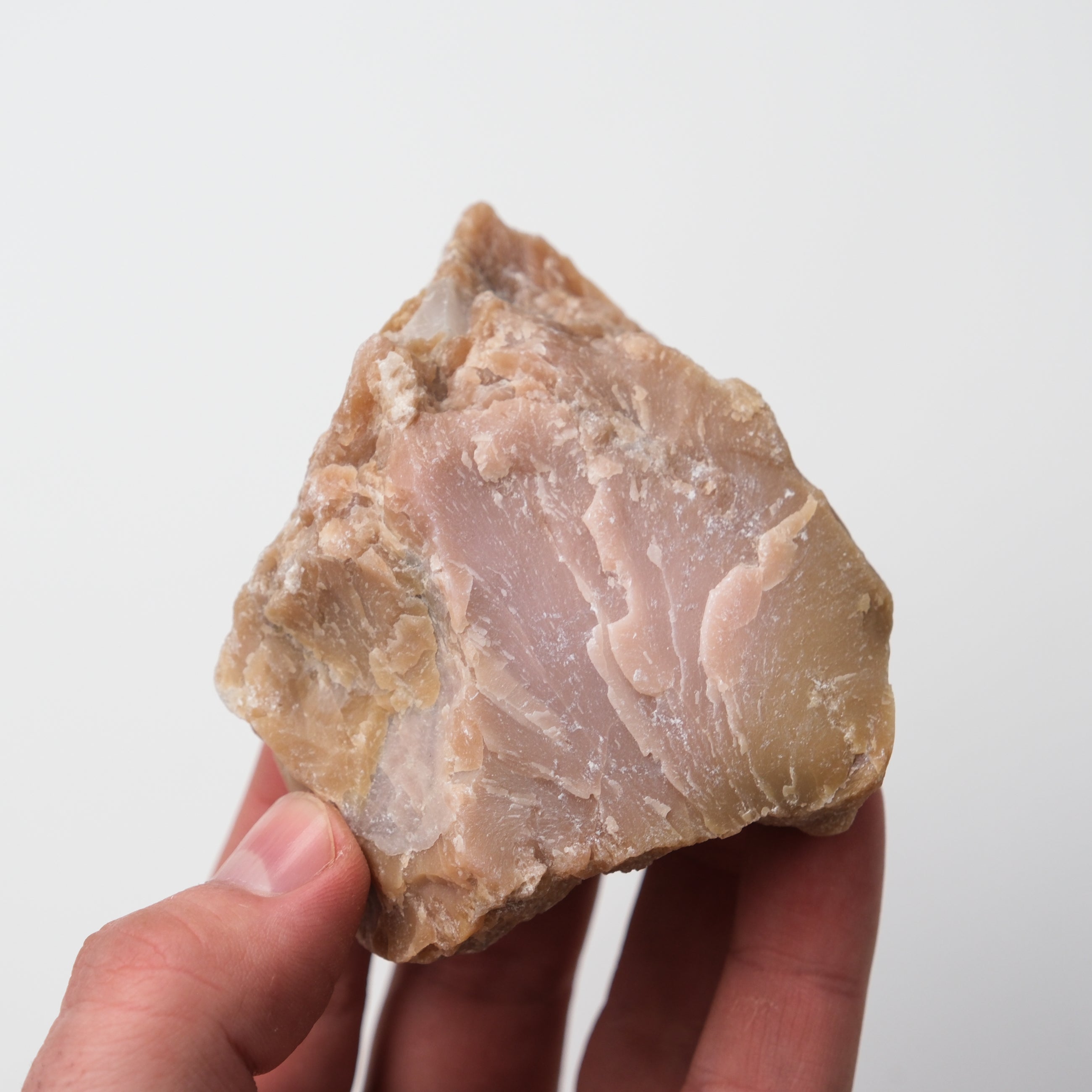 Pink Opal rough gemstone from Noctis Studio with a textured, natural surface showing soft pink hues and rough crystal formation.