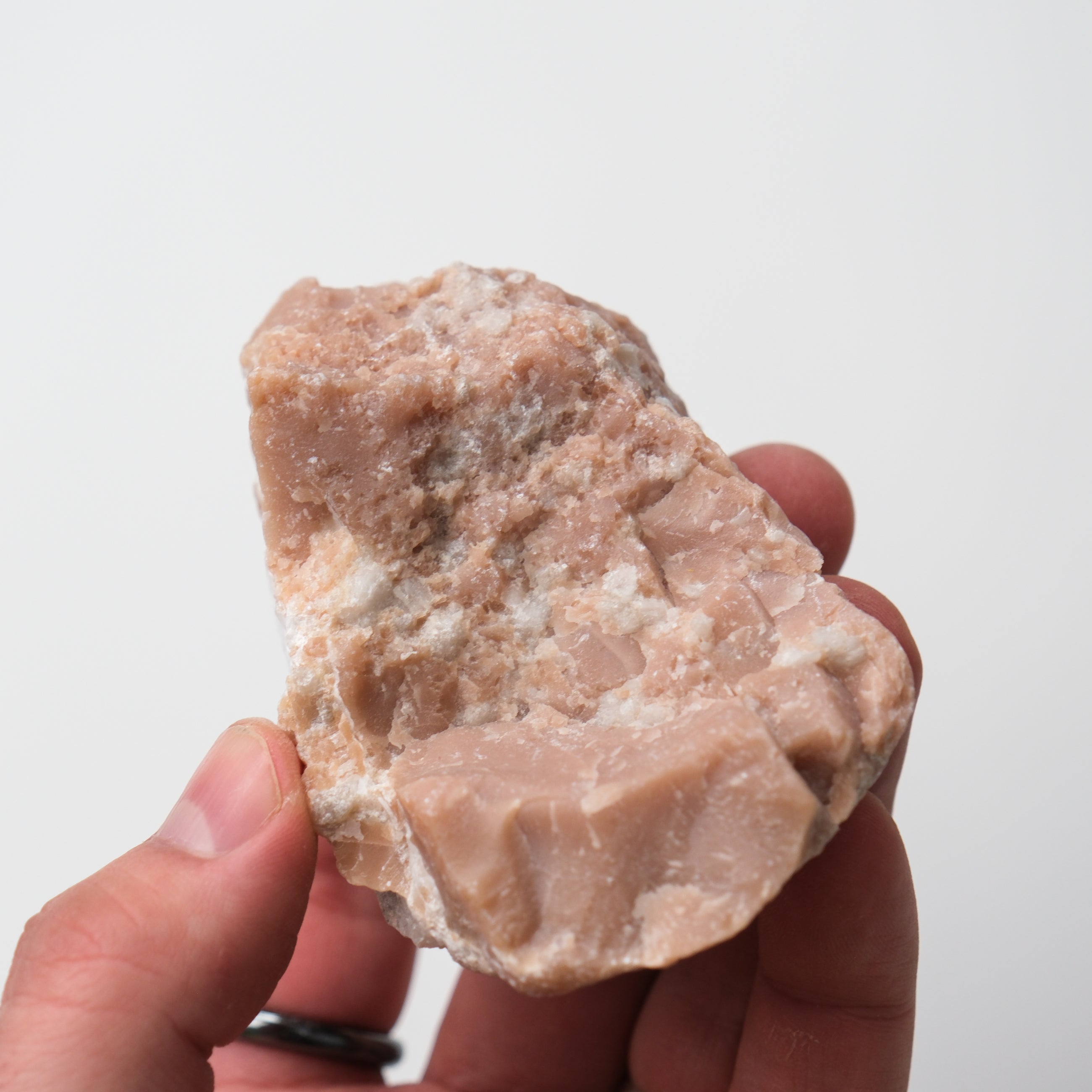 Pink Opal rough gemstone from Noctis Studio, showcasing a textured, natural pink stone with vibrant color and unique rough surface.