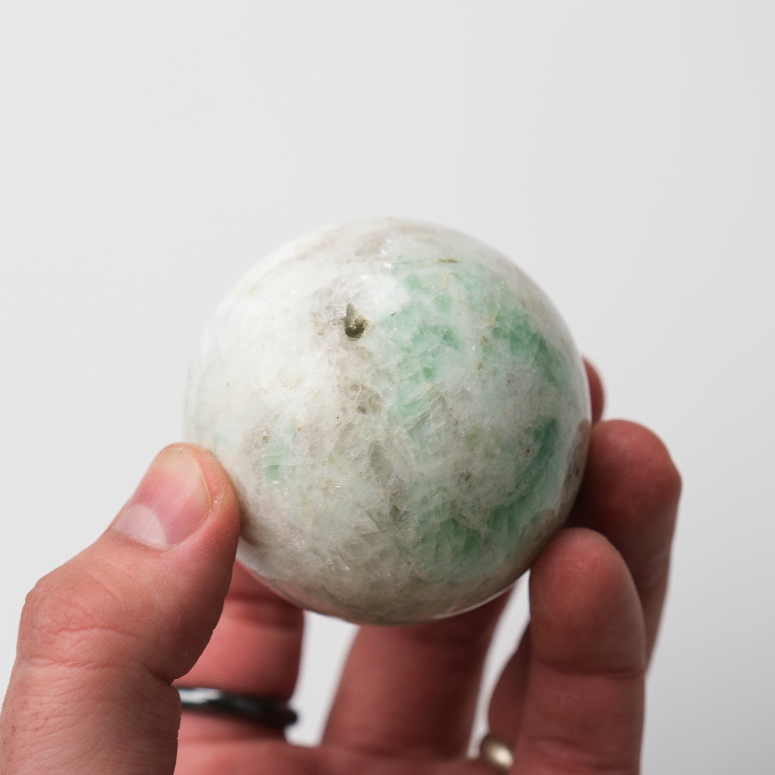 Green Moonstone sphere by Noctis Studio, smooth polished gemstone with luminous green hues and natural moonstone pattern.