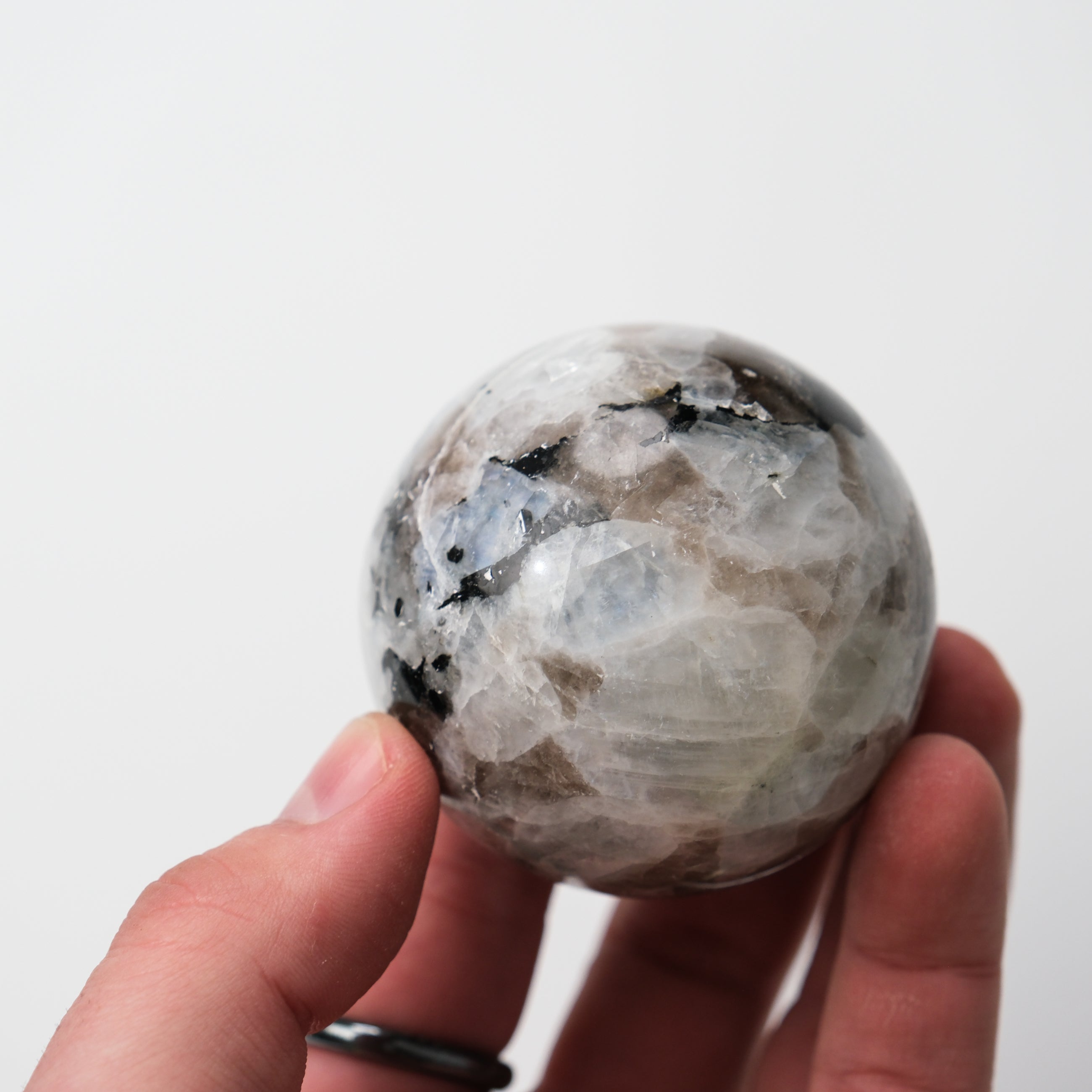 Noctis Studio moonstone sphere with smooth, polished surface showcasing the iridescent, translucent gemstone on a plain background.