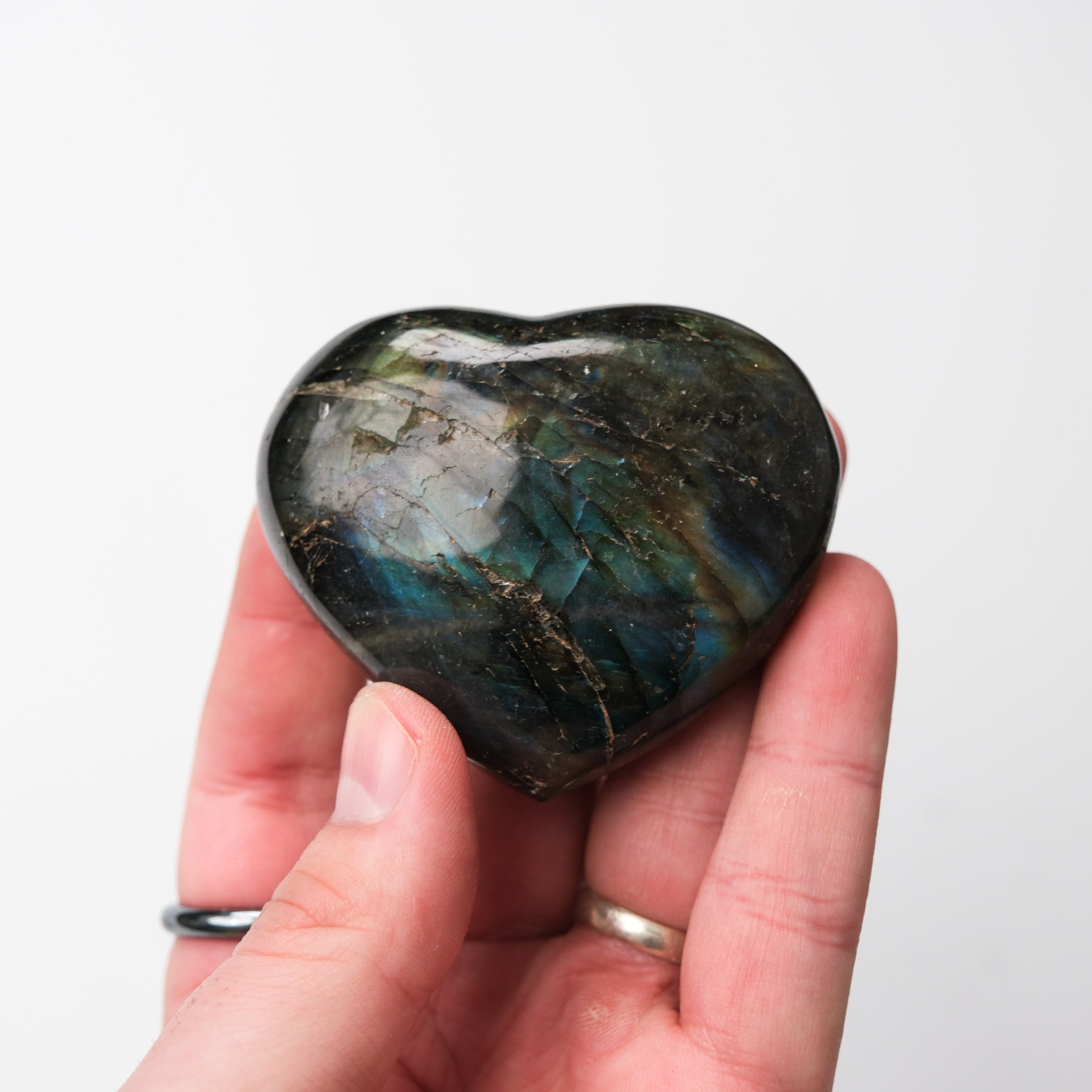 Labradorite heart gemstone pendant from Noctis Studio with iridescent blue and green flashes, smooth polished surface.