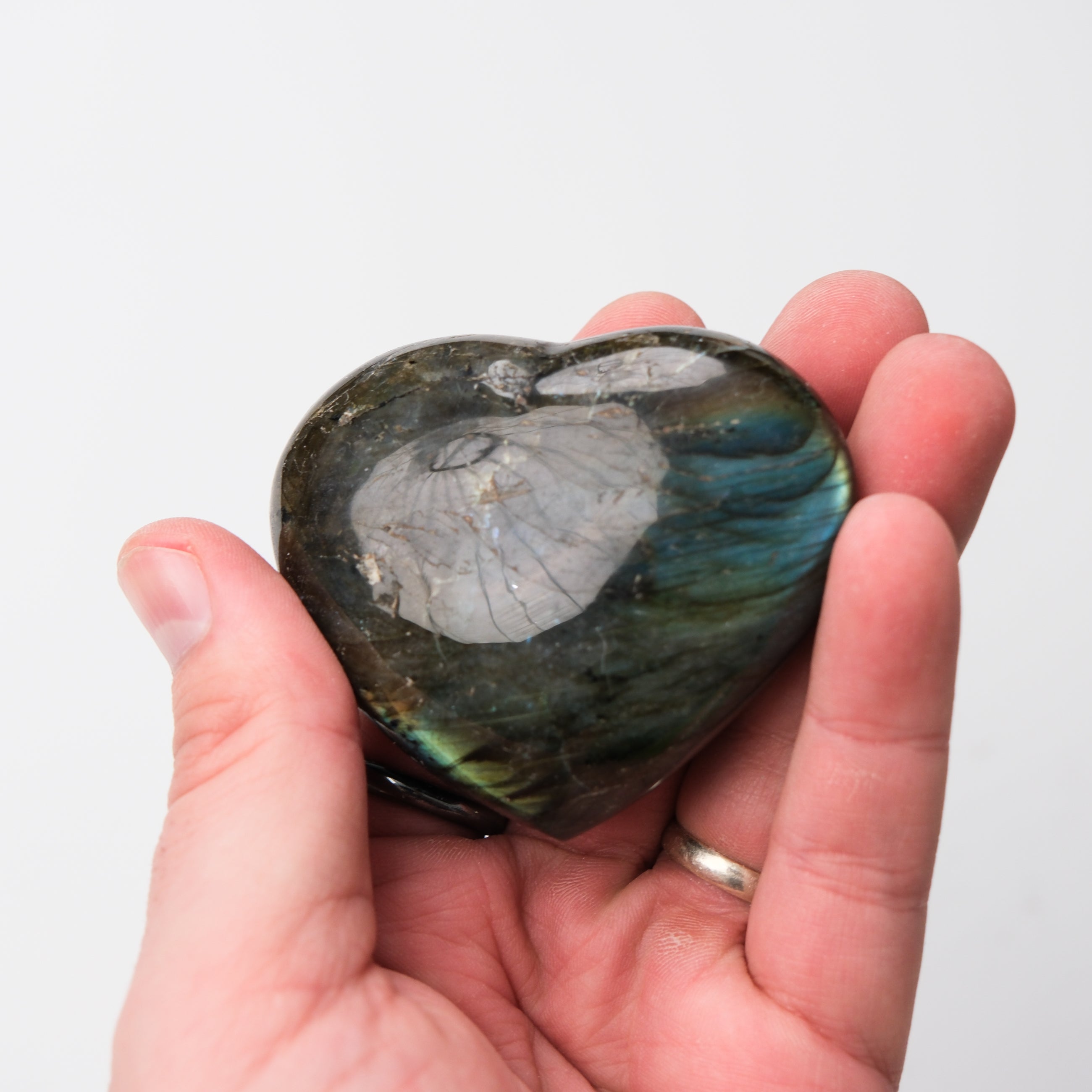 Labradorite heart-shaped gemstone from Noctis Studio with iridescent blue and green flashes, smooth polished surface.
