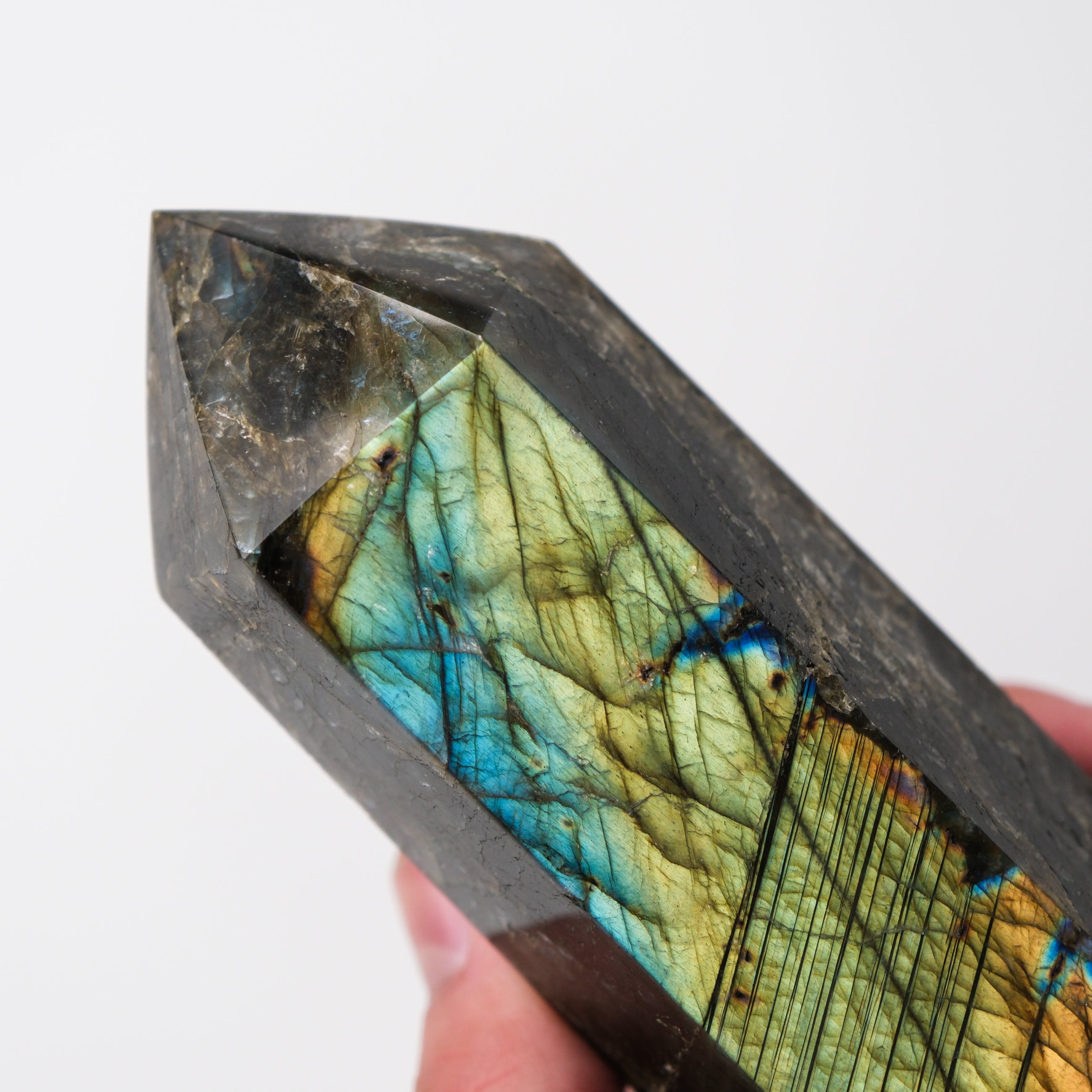 Labradorite pillar sculpture by Noctis Studio featuring a polished, natural gemstone with iridescent blue and green hues.