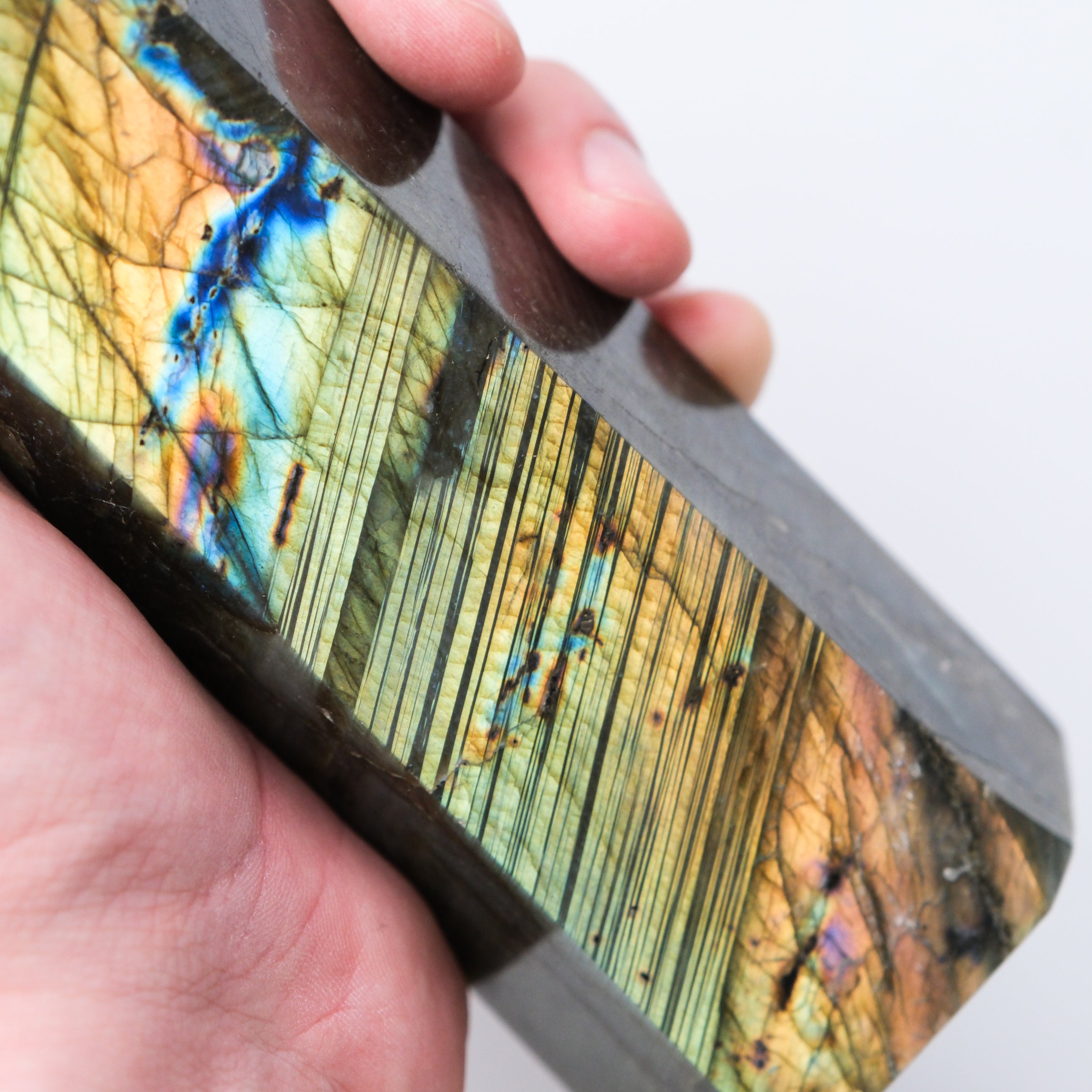 Labradorite pillar sculpture by Noctis Studio showing iridescent blue and green hues with polished stone surface.