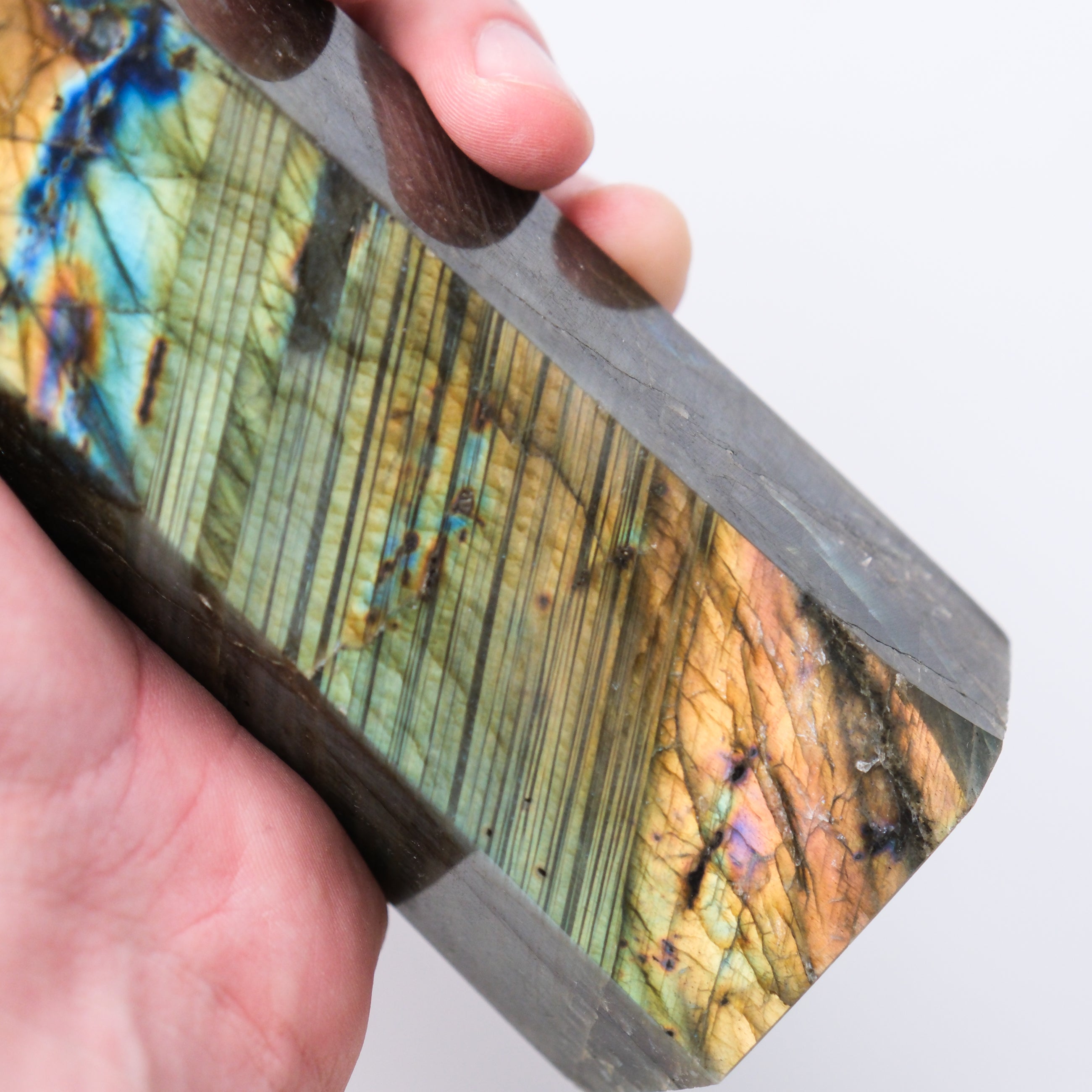 Labradorite pillar sculpture by Noctis Studio, polished stone with iridescent flashes, displayed on a neutral background.
