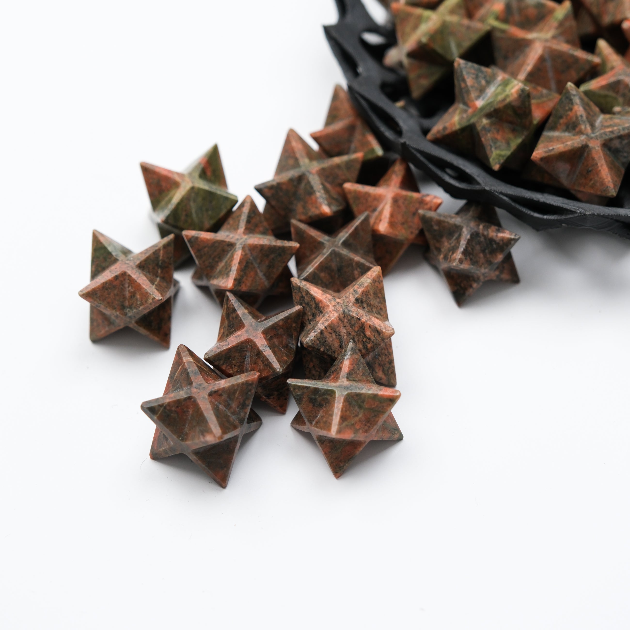 Unakite star gemstone from Noctis Studio, polished and faceted, showcasing vibrant green and pink hues.