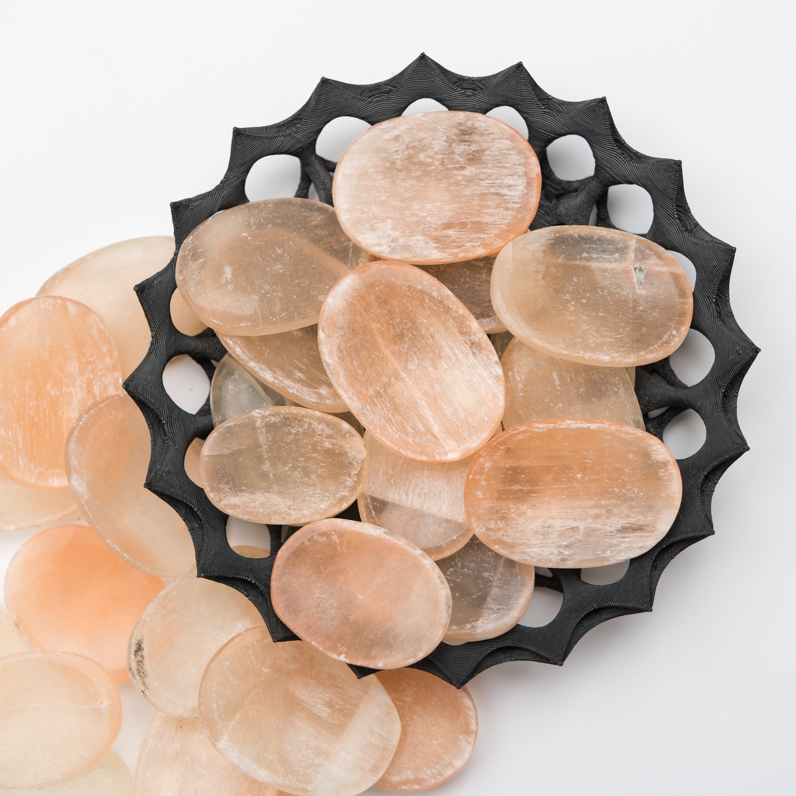Orange Selenite worry stone from Noctis Studio, smooth polished gemstone with a rounded shape, used for stress relief and meditation.