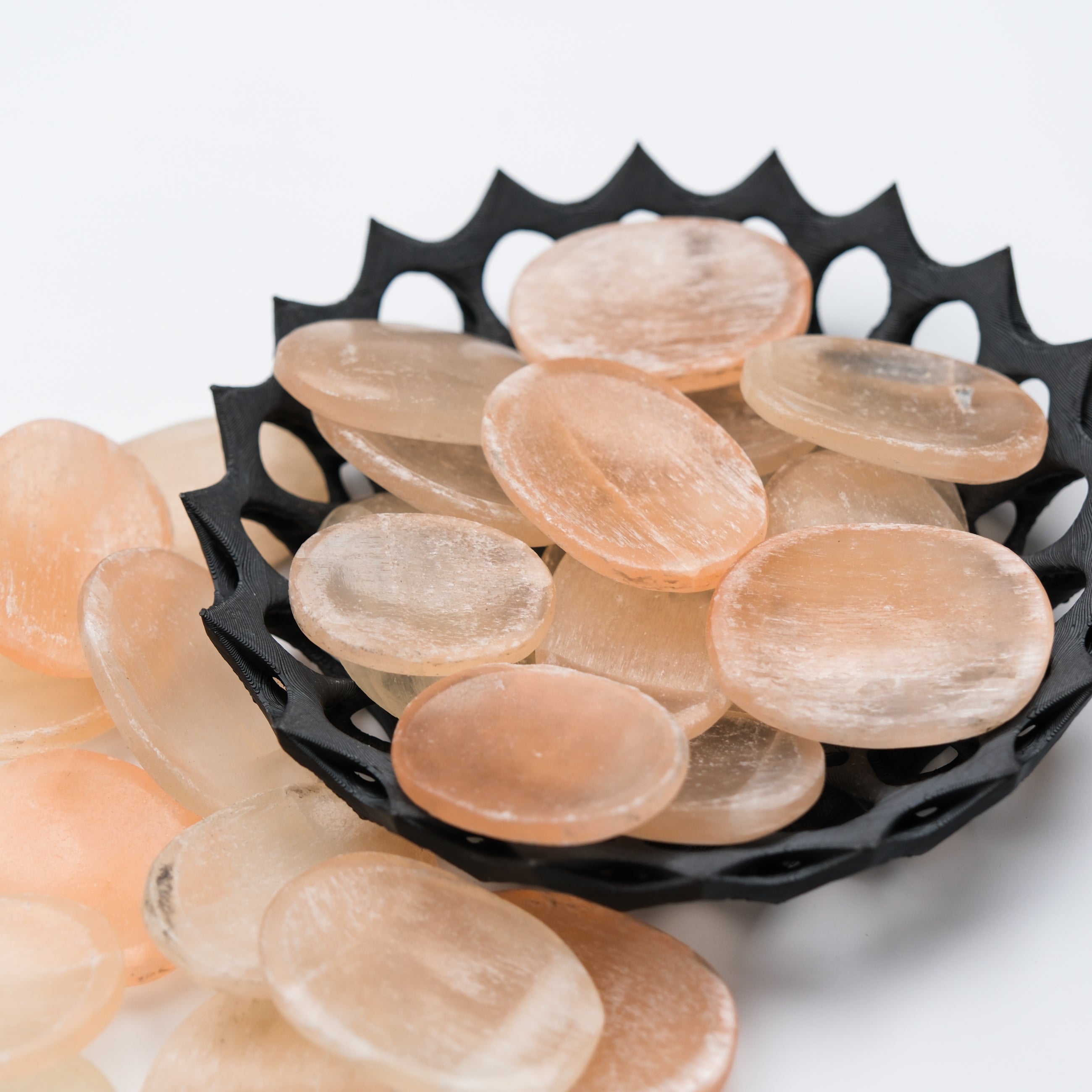 Orange Selenite worry stone from Noctis Studio, smooth polished crystal with a rounded shape and natural striations.