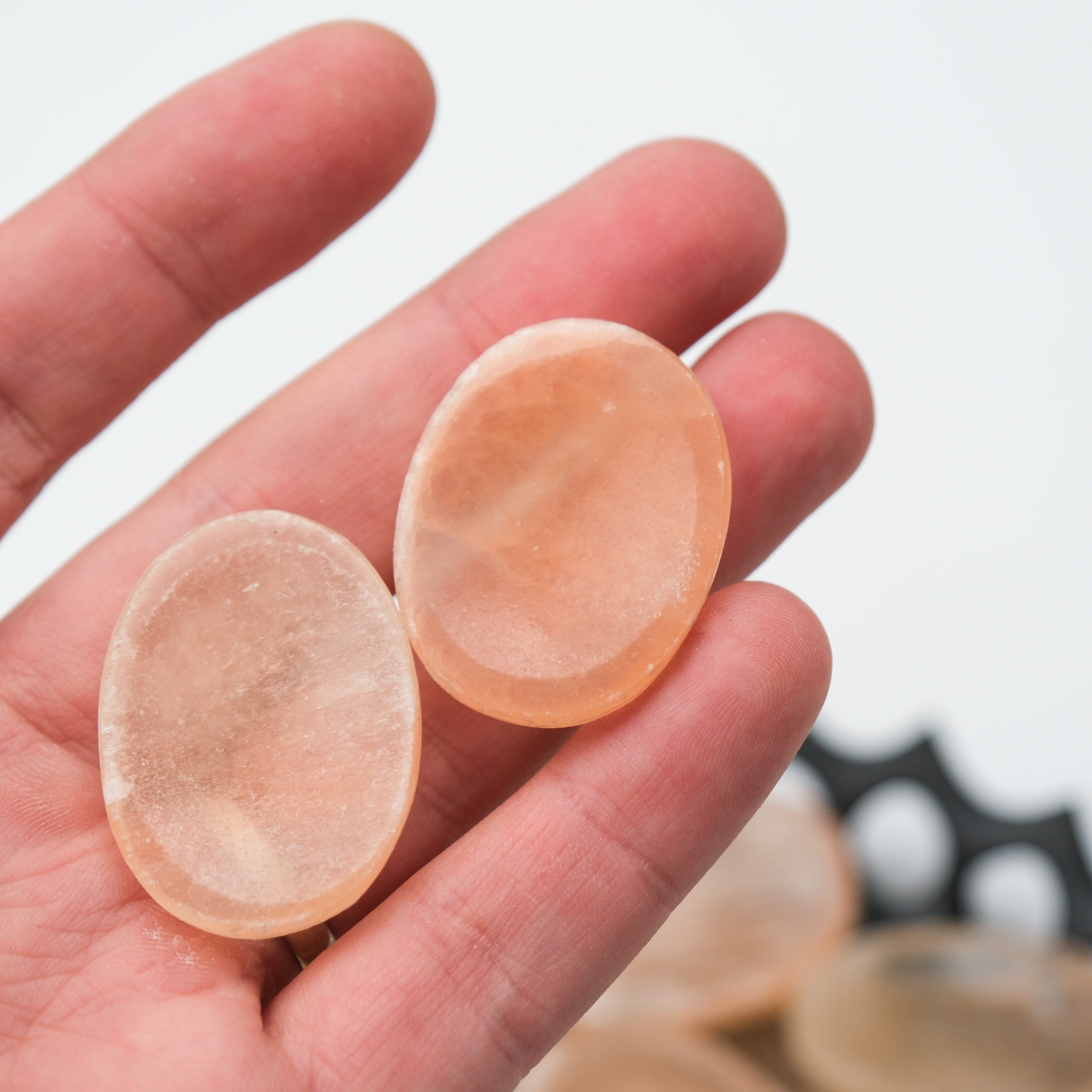 Orange Selenite worry stone from Noctis Studio, smooth polished handheld crystal with a vibrant orange hue.