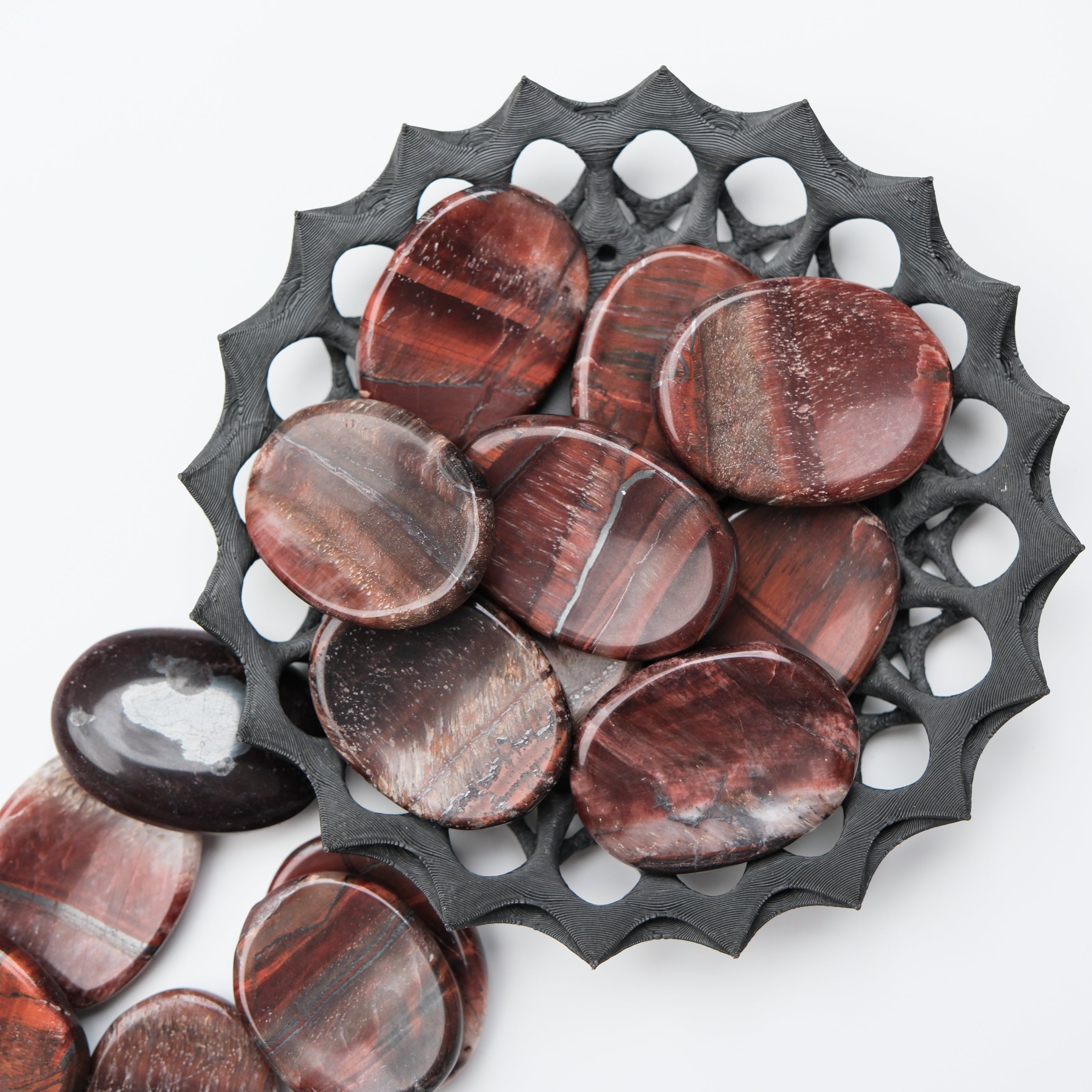 Red Tigers Eye worry stone by Noctis Studio with polished smooth surface and natural gemstone appearance.