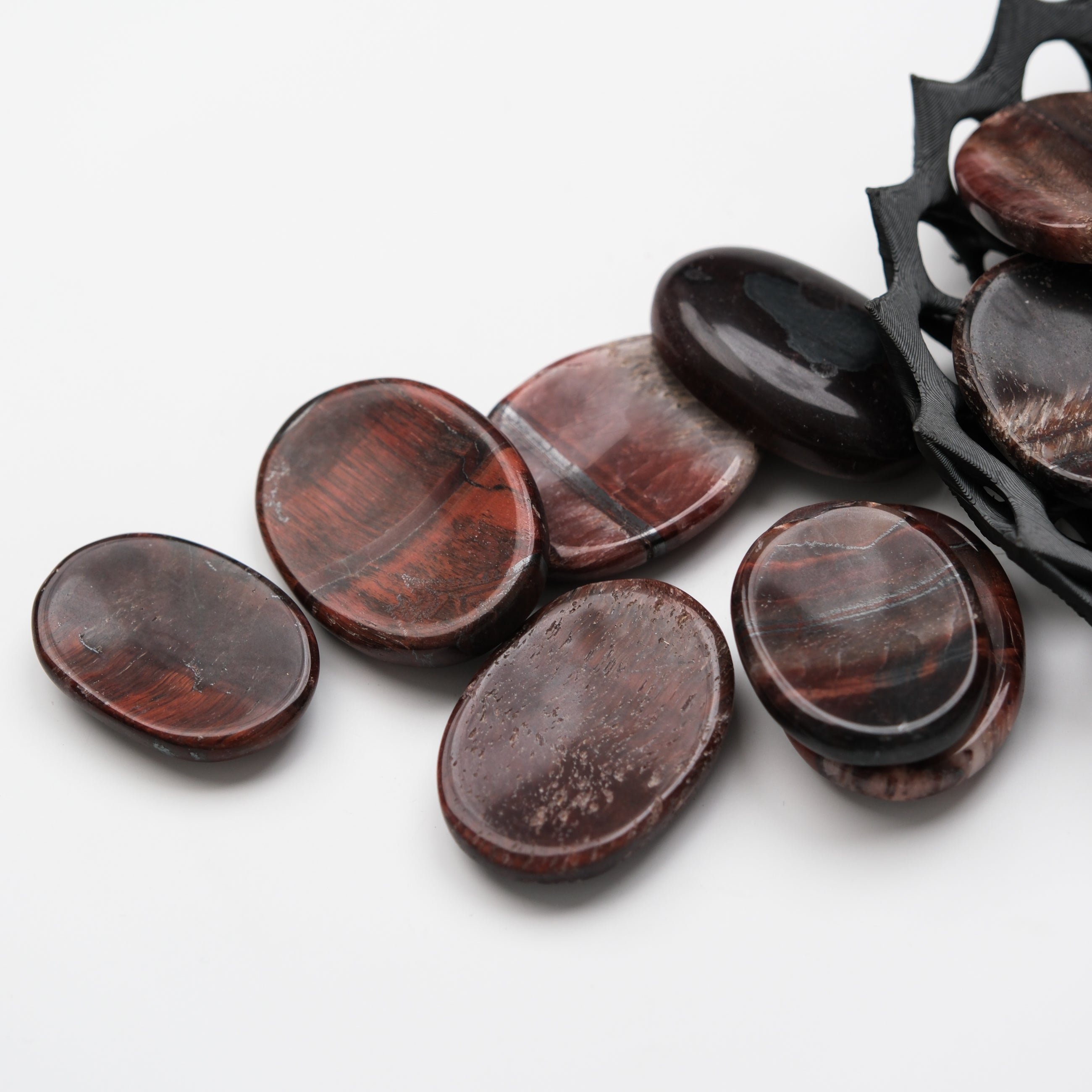 Red Tigers Eye worry stone from Noctis Studio, smooth gemstone with natural striations and polished finish for calming use.