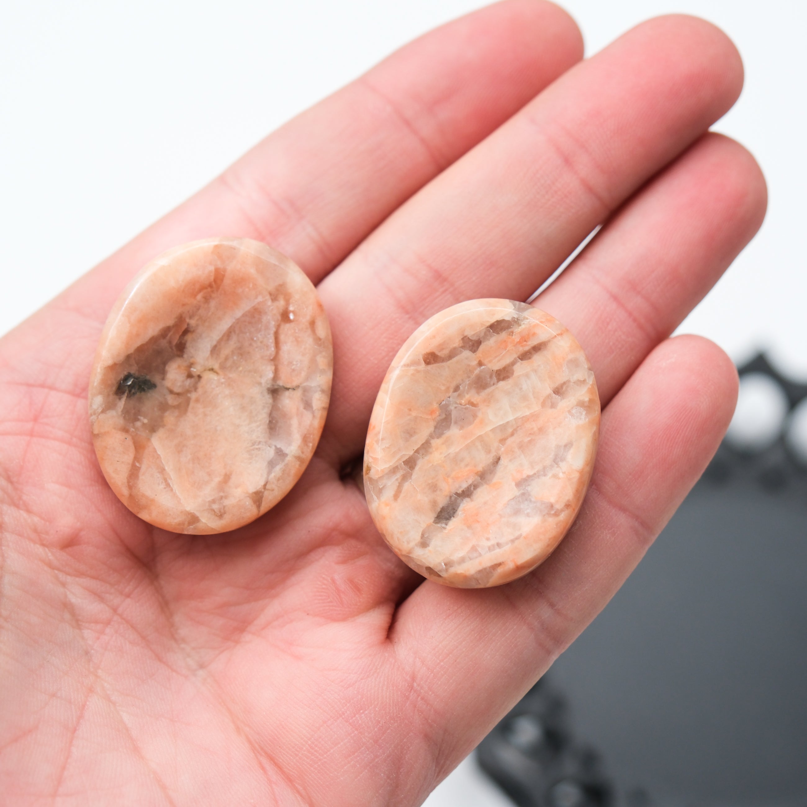 Orange moonstone worry stone from Noctis Studio, smooth oval gemstone with vibrant orange color and natural moonstone pattern.