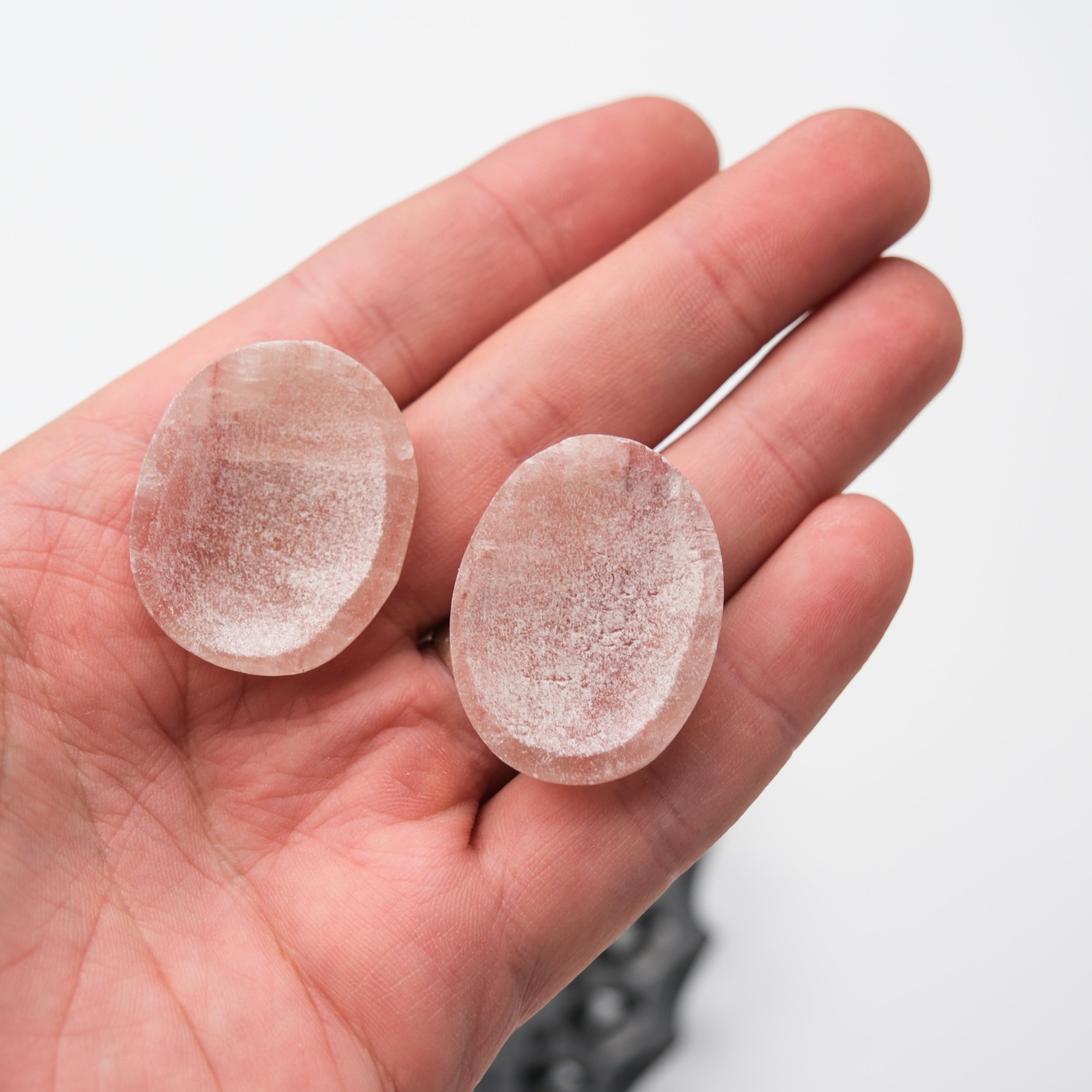 Rose Calcite worry stone by Noctis Studio showing smooth, polished pink stone with subtle natural veining and rounded edges.