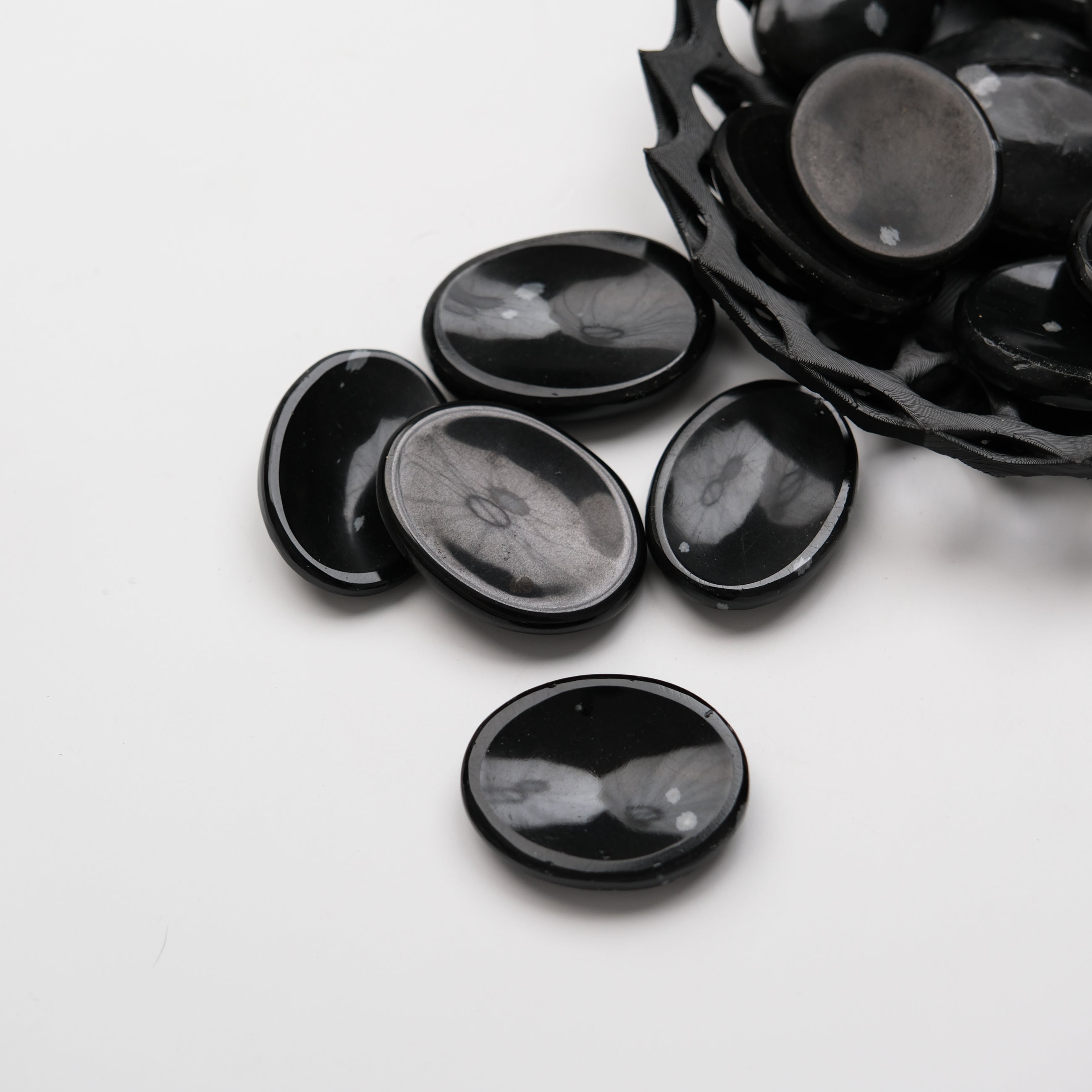 Snowflake Obsidian worry stone from Noctis Studio, polished smooth gemstone with distinctive white snowflake patterns.