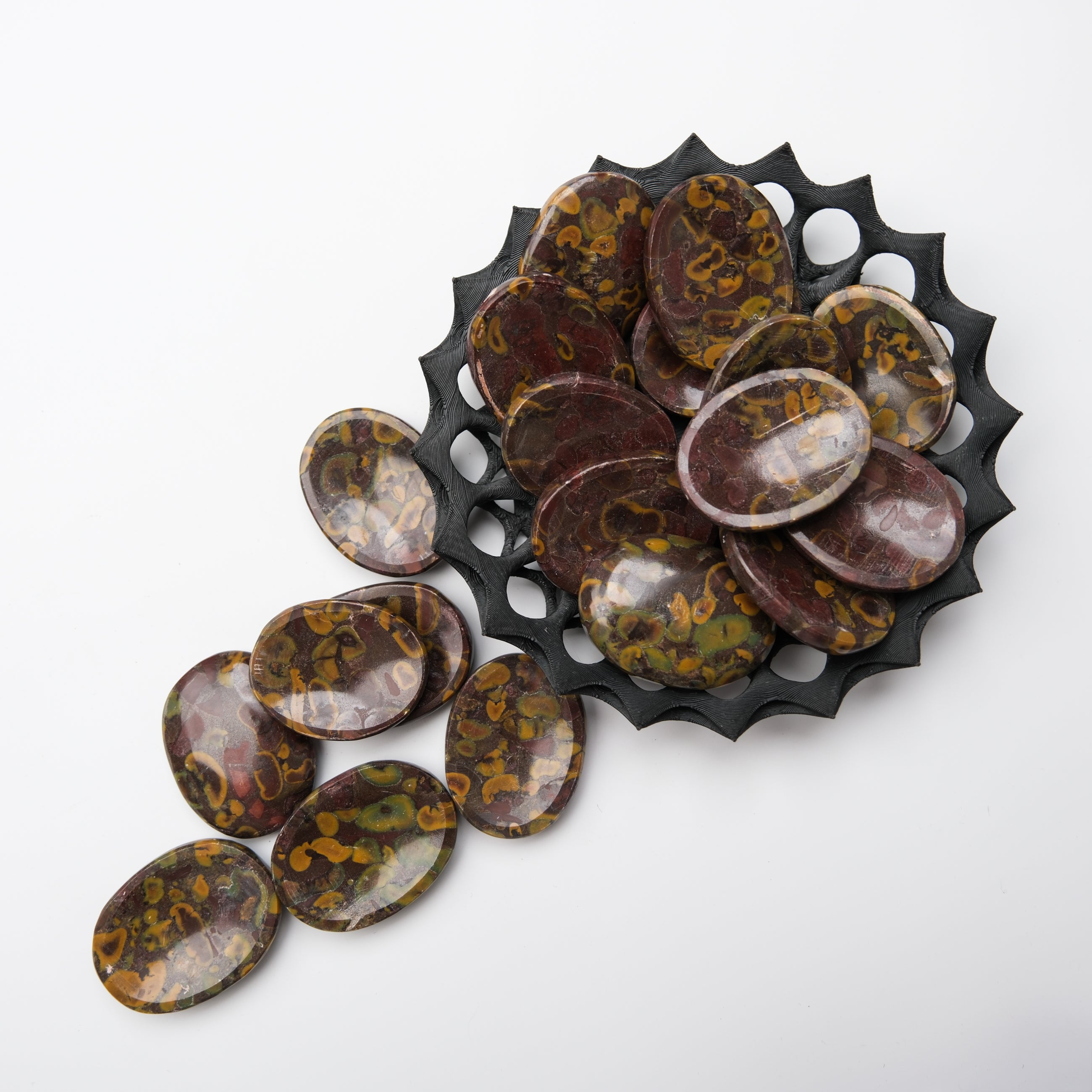 Smooth fruit Jasper worry stone from Noctis Studio, showing vibrant orange and green patterns on a polished surface.