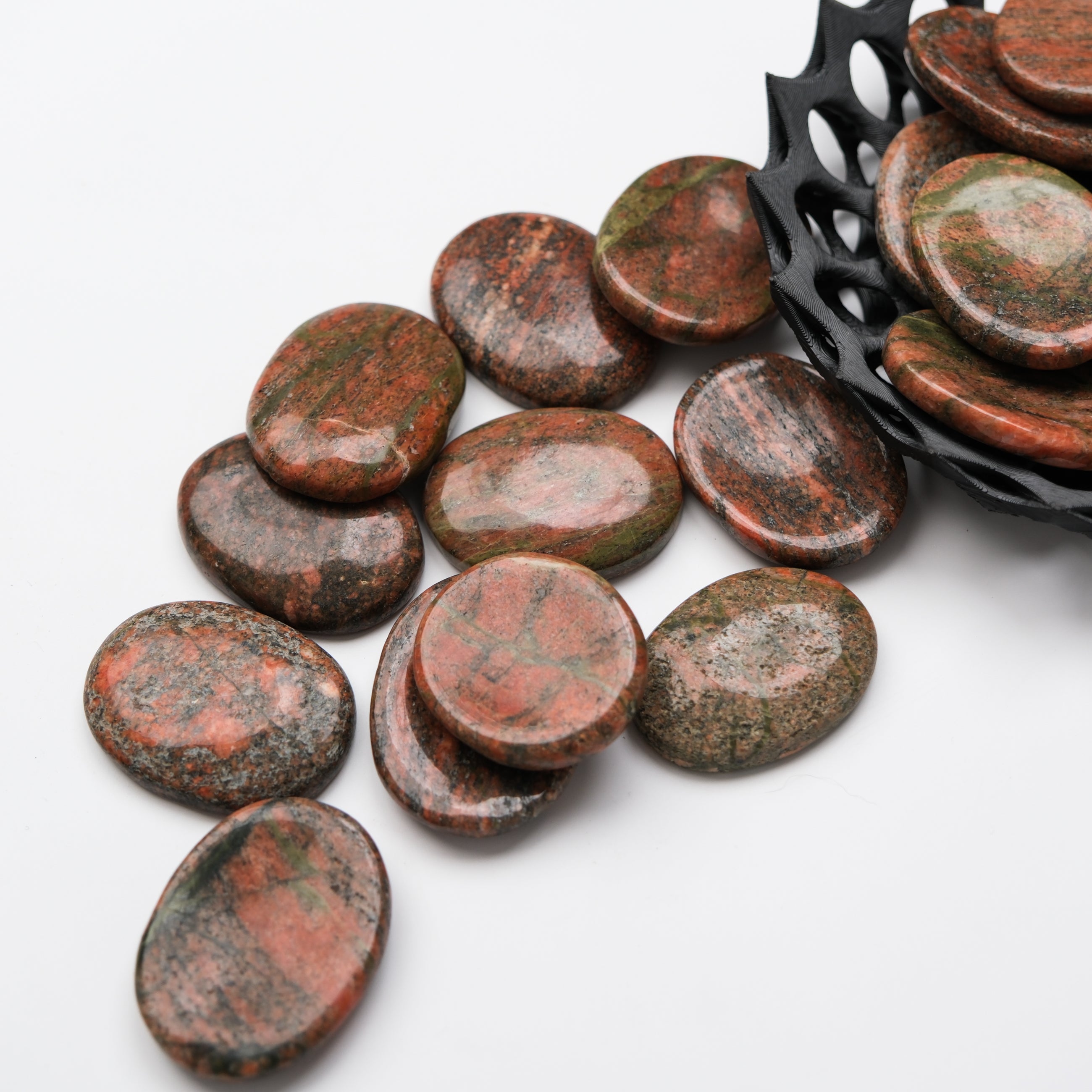 Unakite worry stone from Noctis Studio with smooth, polished surface and natural green and pink hues, used for stress relief and meditation.